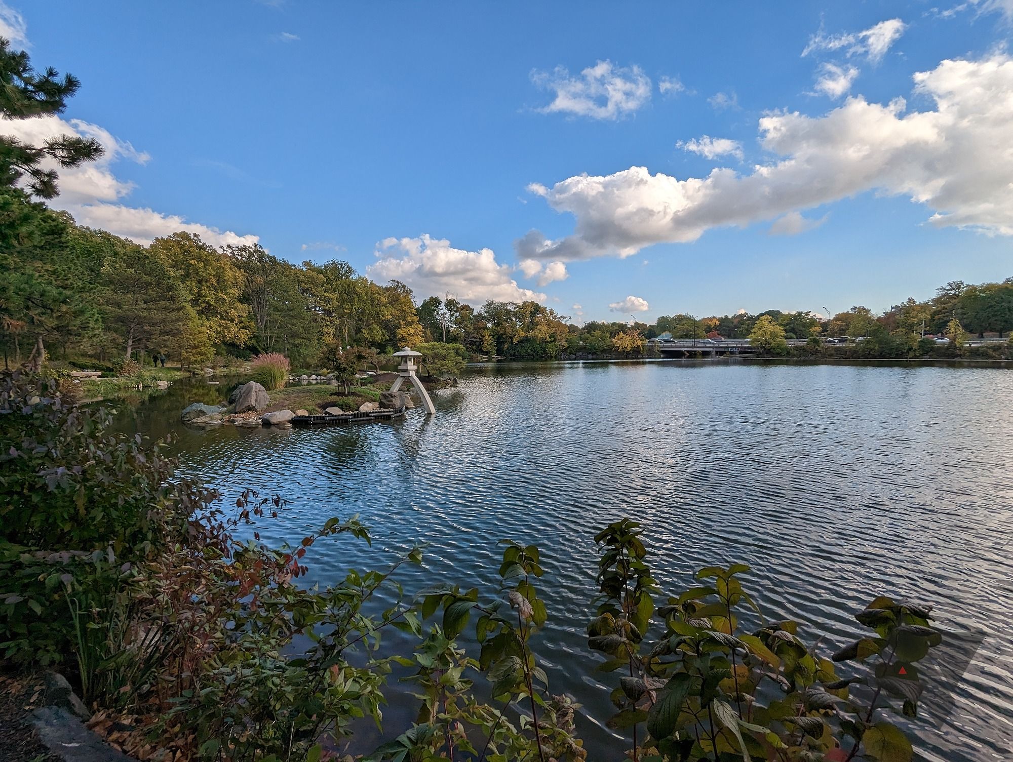 Uma foto grande angular de um lago cercado por árvores tirada em um Pixel 7.