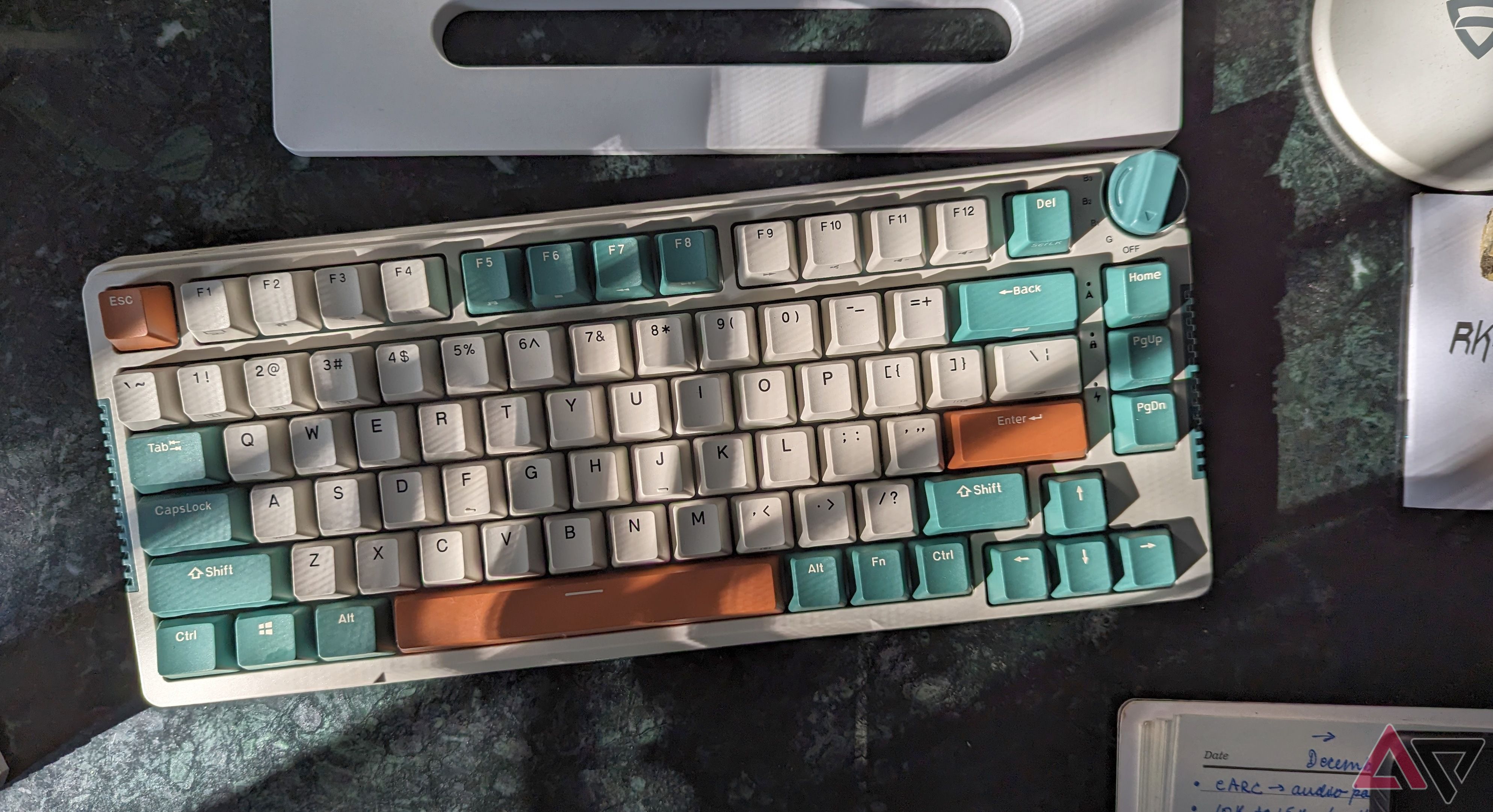 Foto do estilo de vida do teclado mecânico RK H81 deitado na mesa com sombras nas teclas