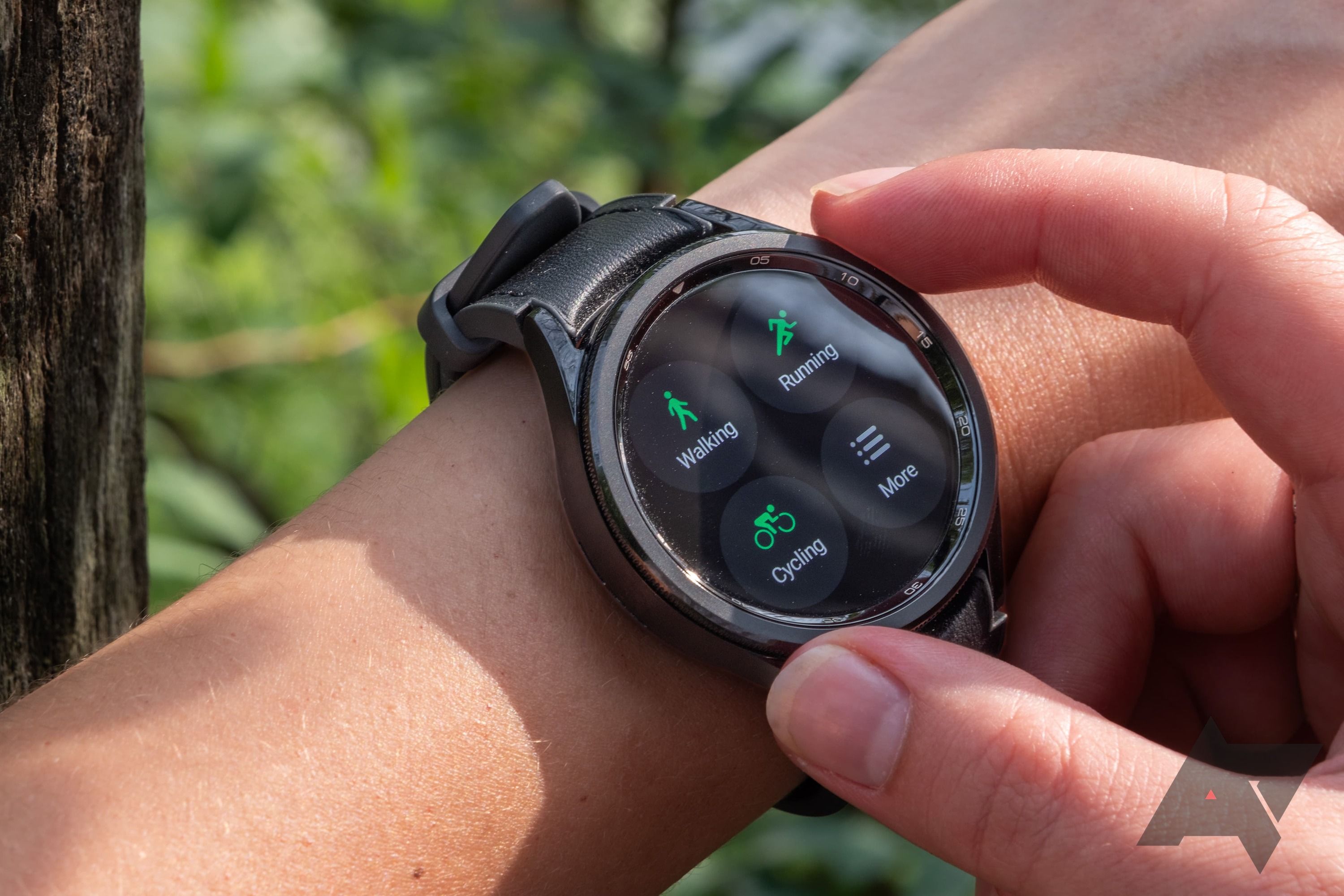 Um smartwatch no pulso mostrando opções de monitoramento de exercícios. 