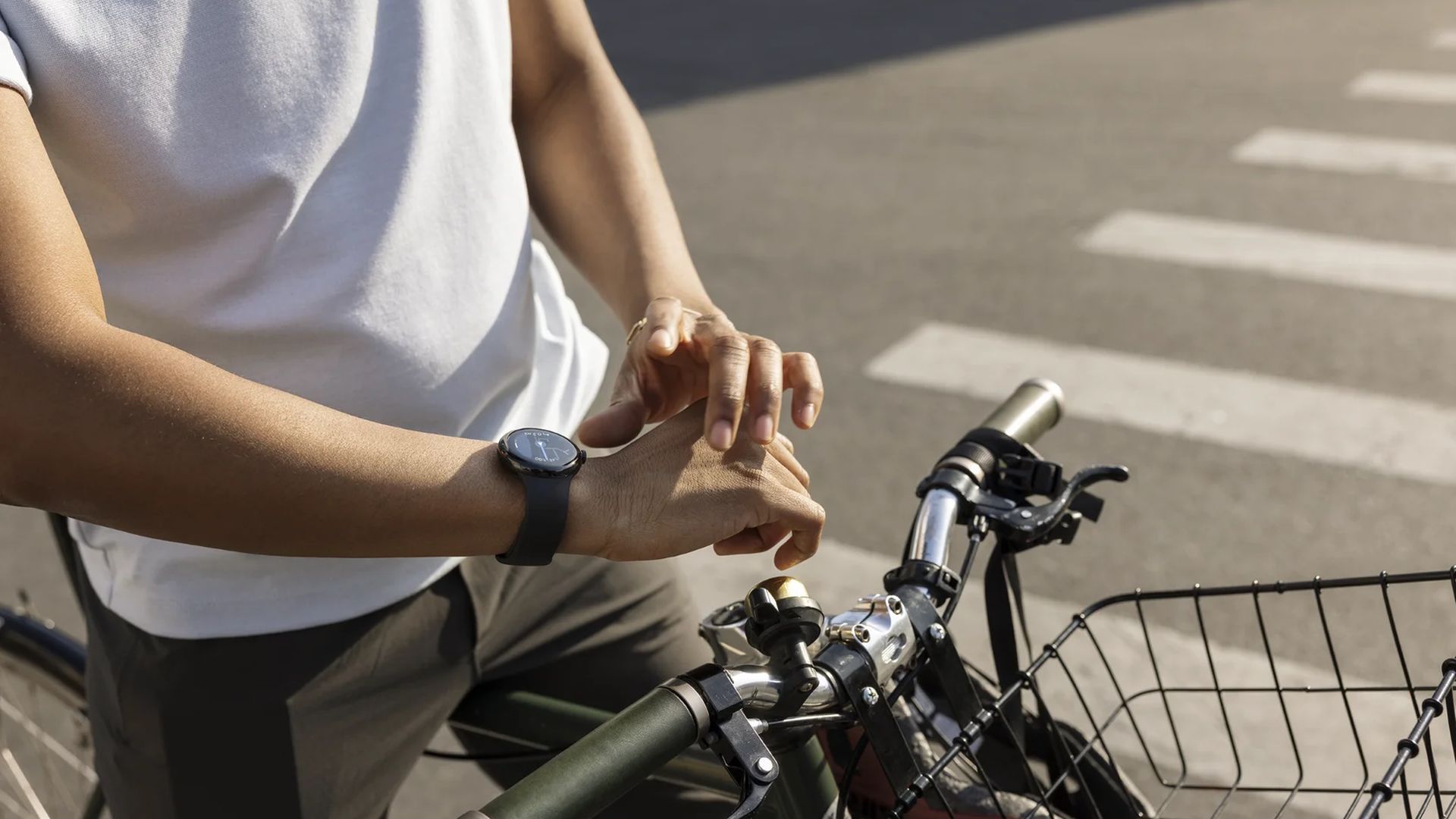 Uma pessoa em uma bicicleta usando um Google Pixel Watch 2 com uma pulseira de obsidiana