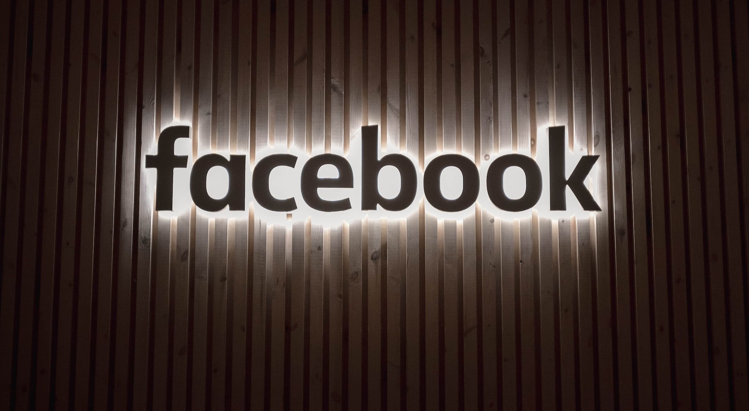 Logotipo do Facebook contra uma cerca de madeira