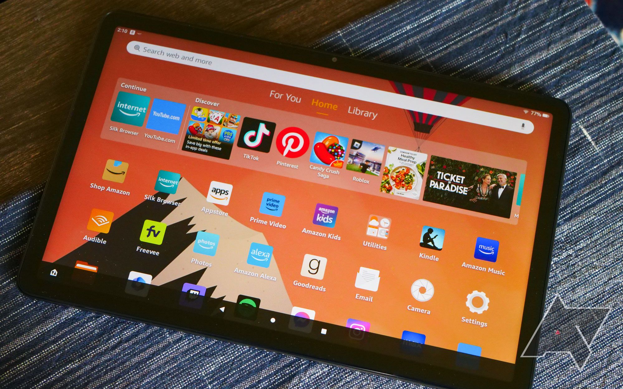 O tablet Amazon Fire Max 11 em cima de uma mesa com a lista de aplicativos aberta.