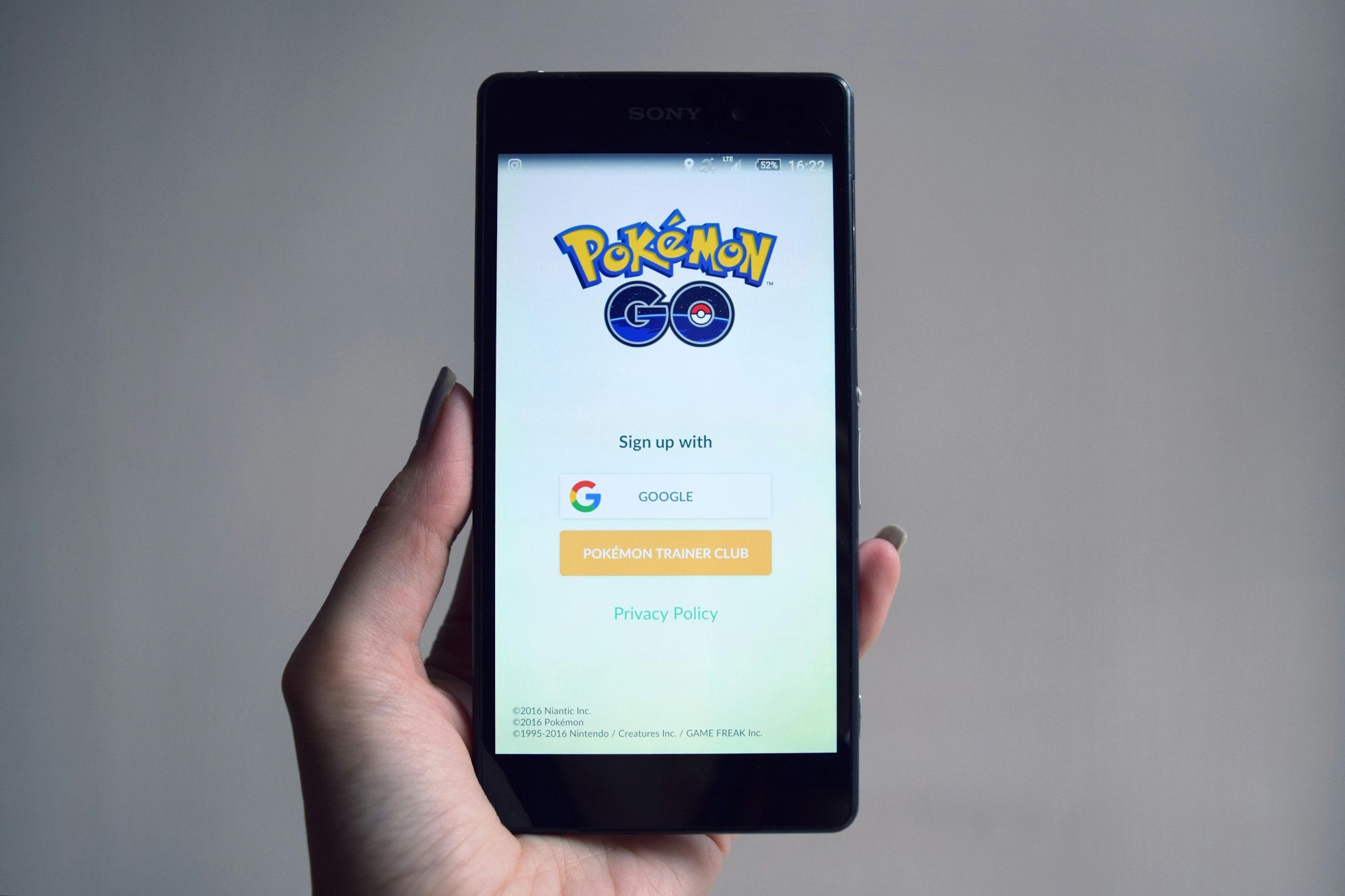 entregando segurando o telefone com o aplicativo Pokémon Go na tela do telefone