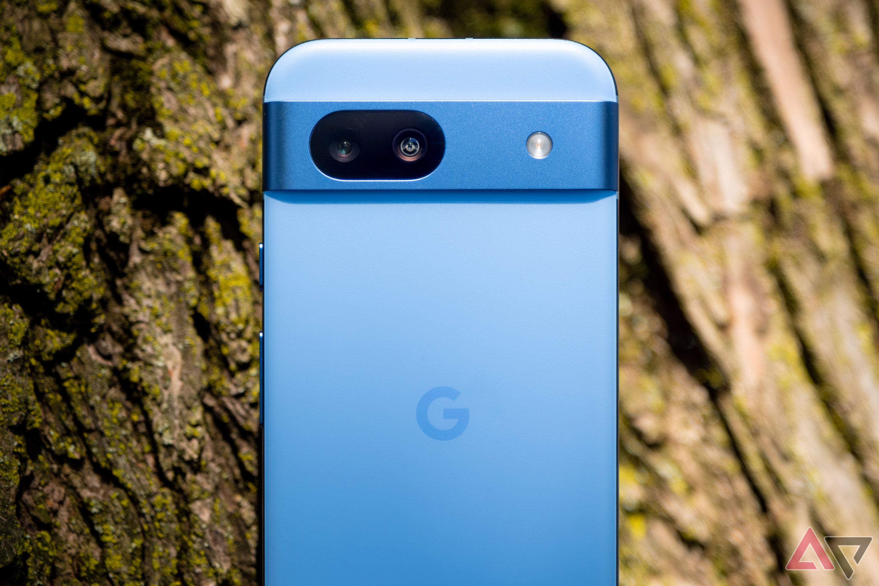 Um smartphone azul na frente de uma árvore