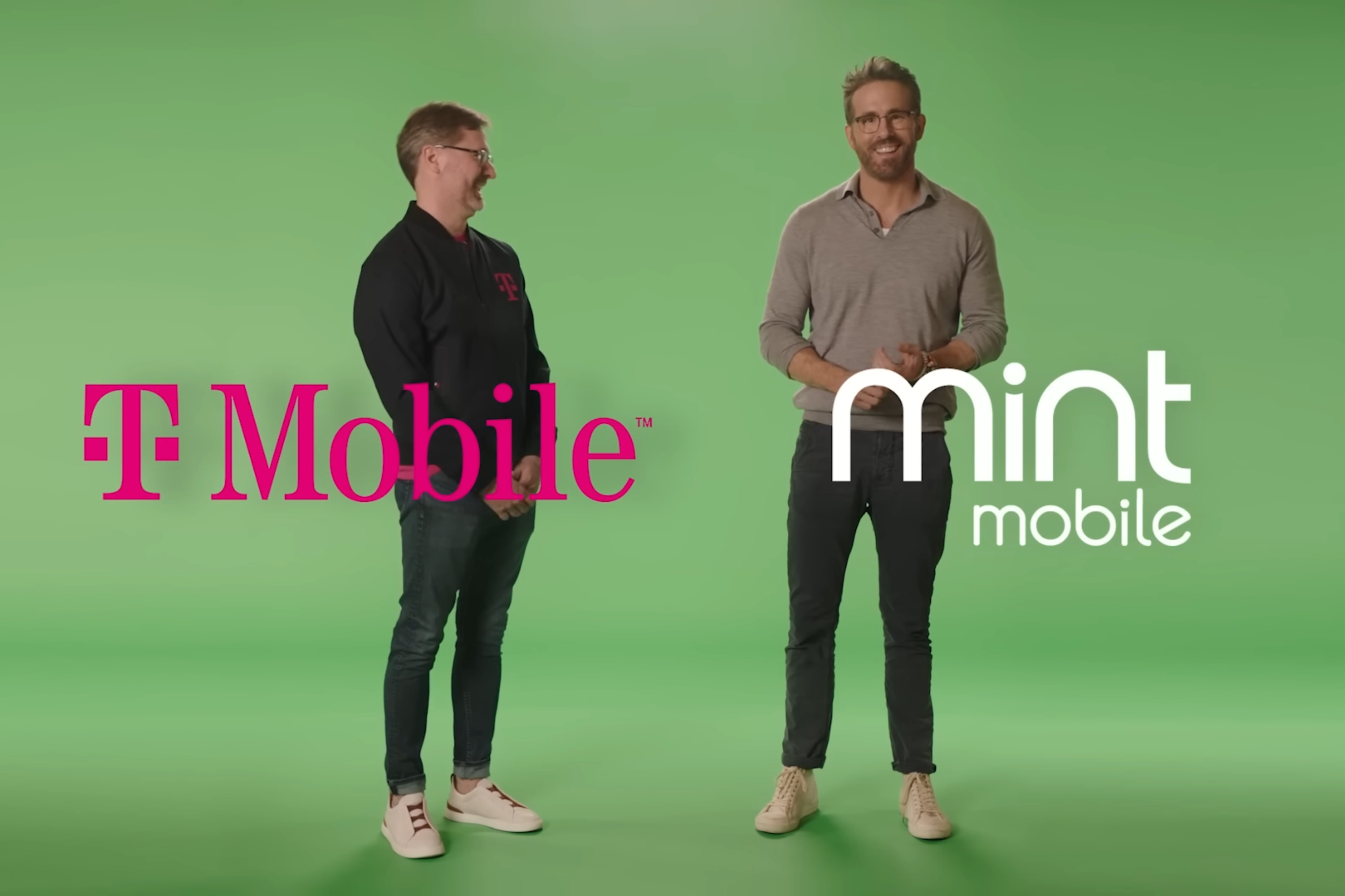 Ryan Reynolds e o CEO da T-Mobile, Mike Sievert, em frente a uma tela verde