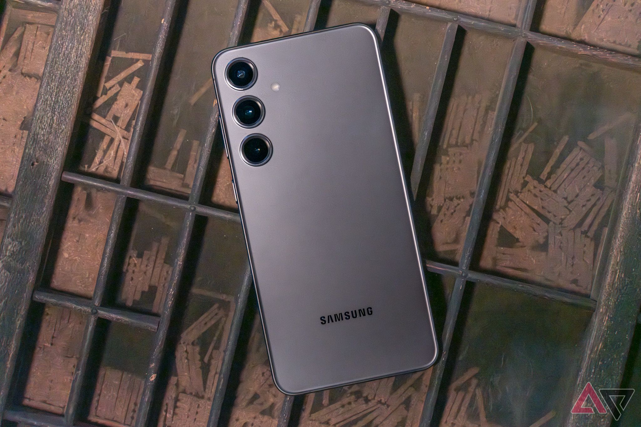 Um Samsung Galaxy S24+ virado para baixo na gaveta de uma impressora