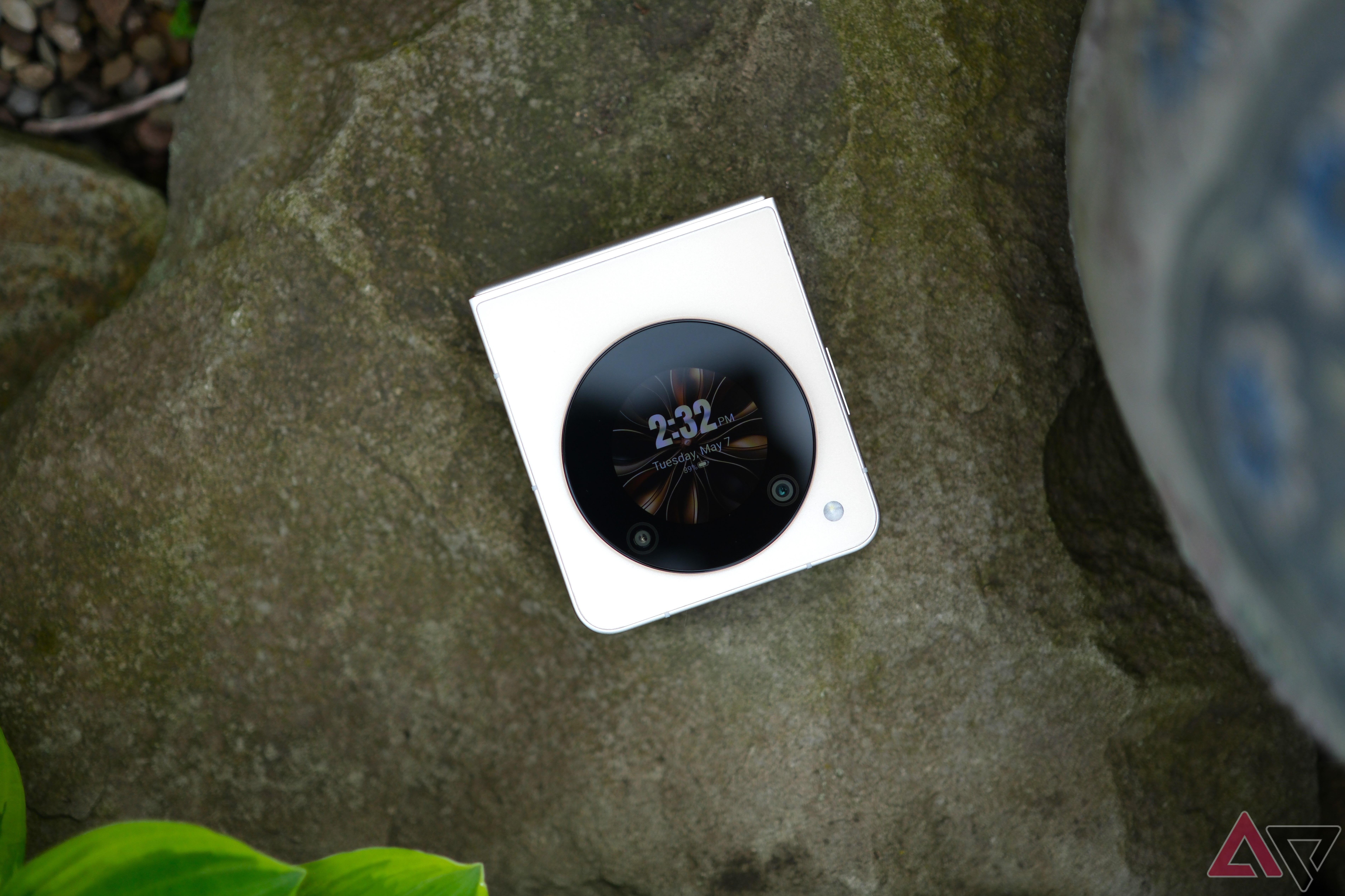 Nubia Flip 5G fechado em uma rocha com tela circular voltada para câmera com relógio na tela