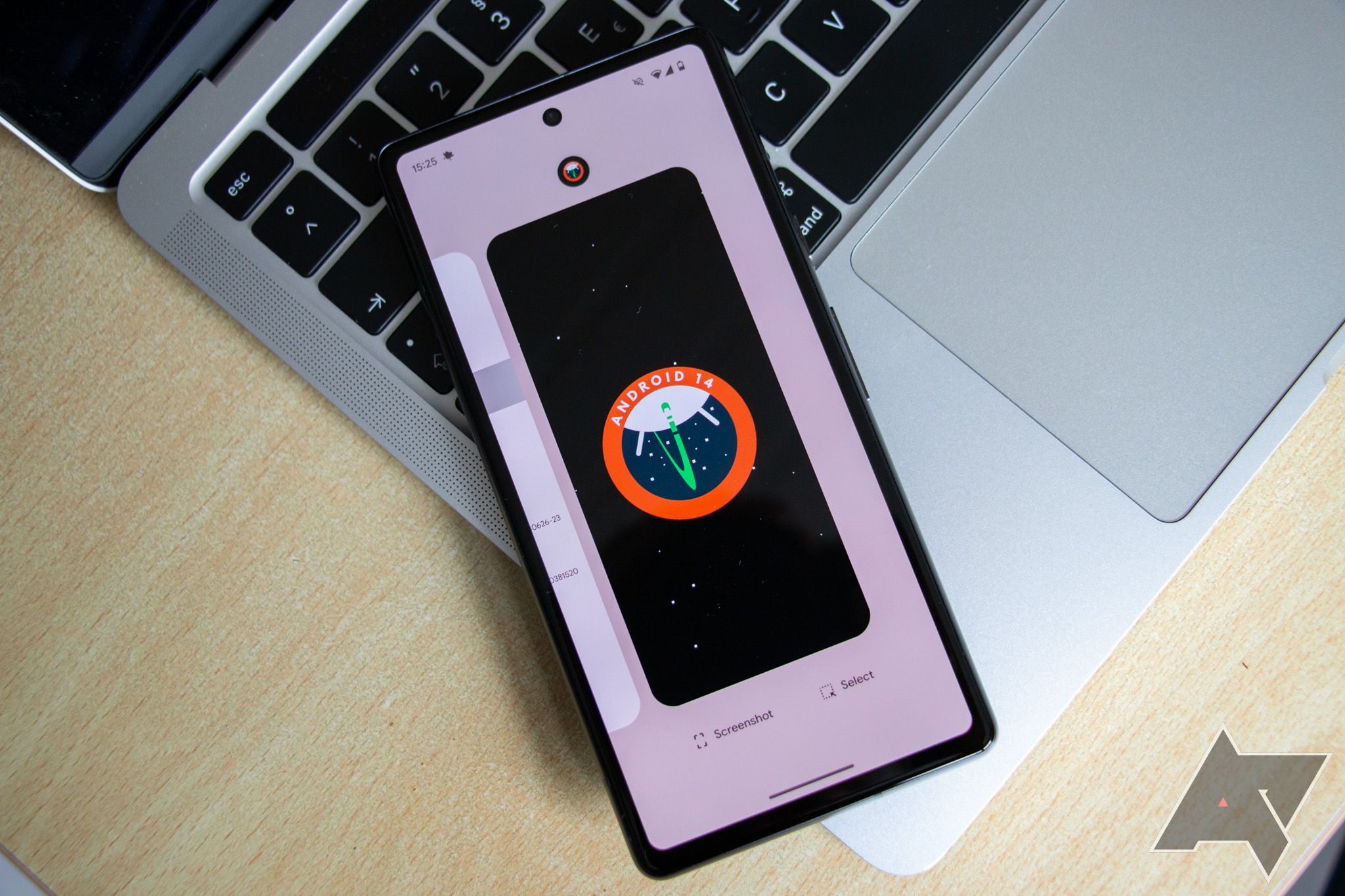 Logotipo do Android 14 em um smartphone colocado sobre o teclado de um laptop