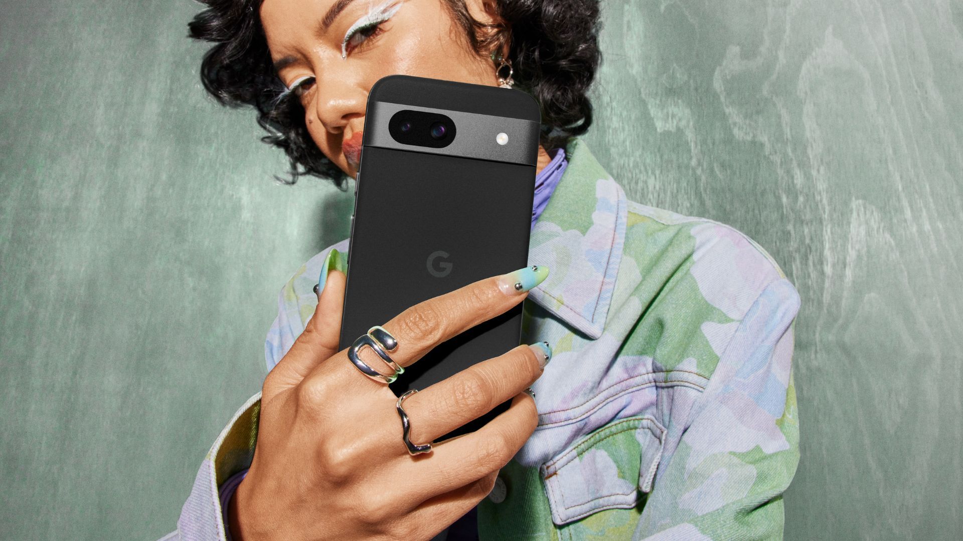 Google Pixel 8a em preto nas mãos exibindo o visor e a cor da câmera