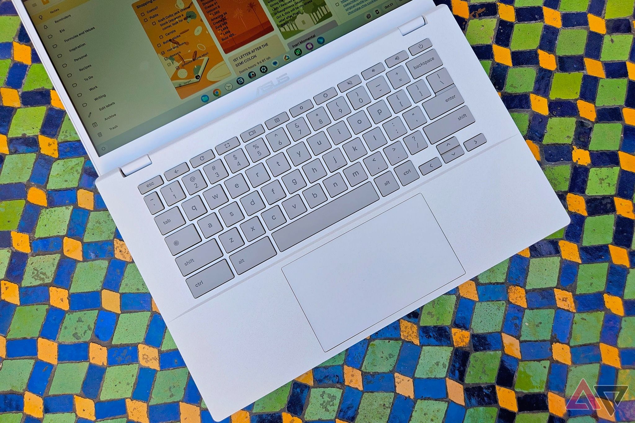 Um Chromebook cinza apoiado em um painel geométrico