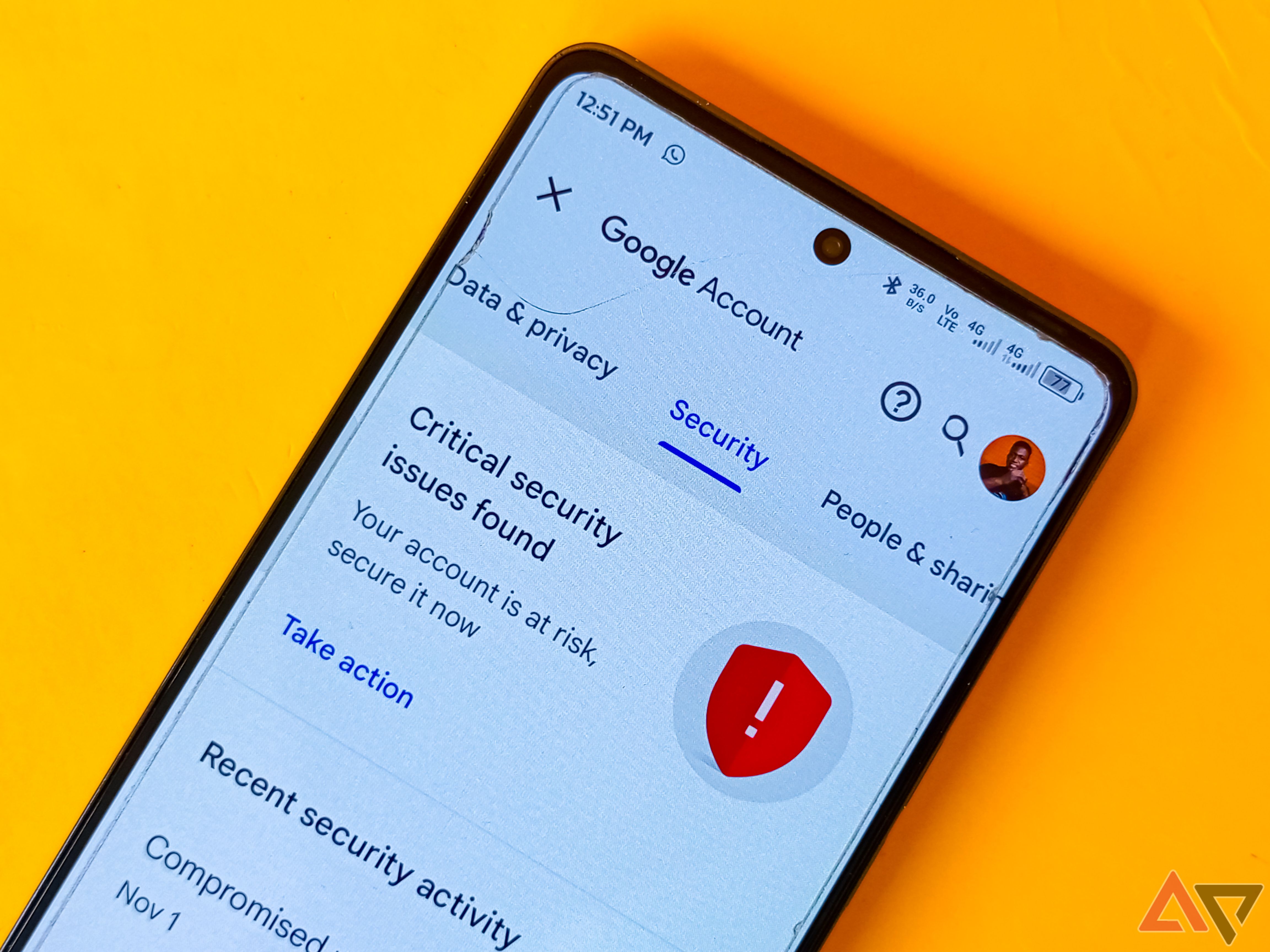 A tela de configurações de segurança da conta do Google capturada em um telefone colocado em um fundo amarelo. 