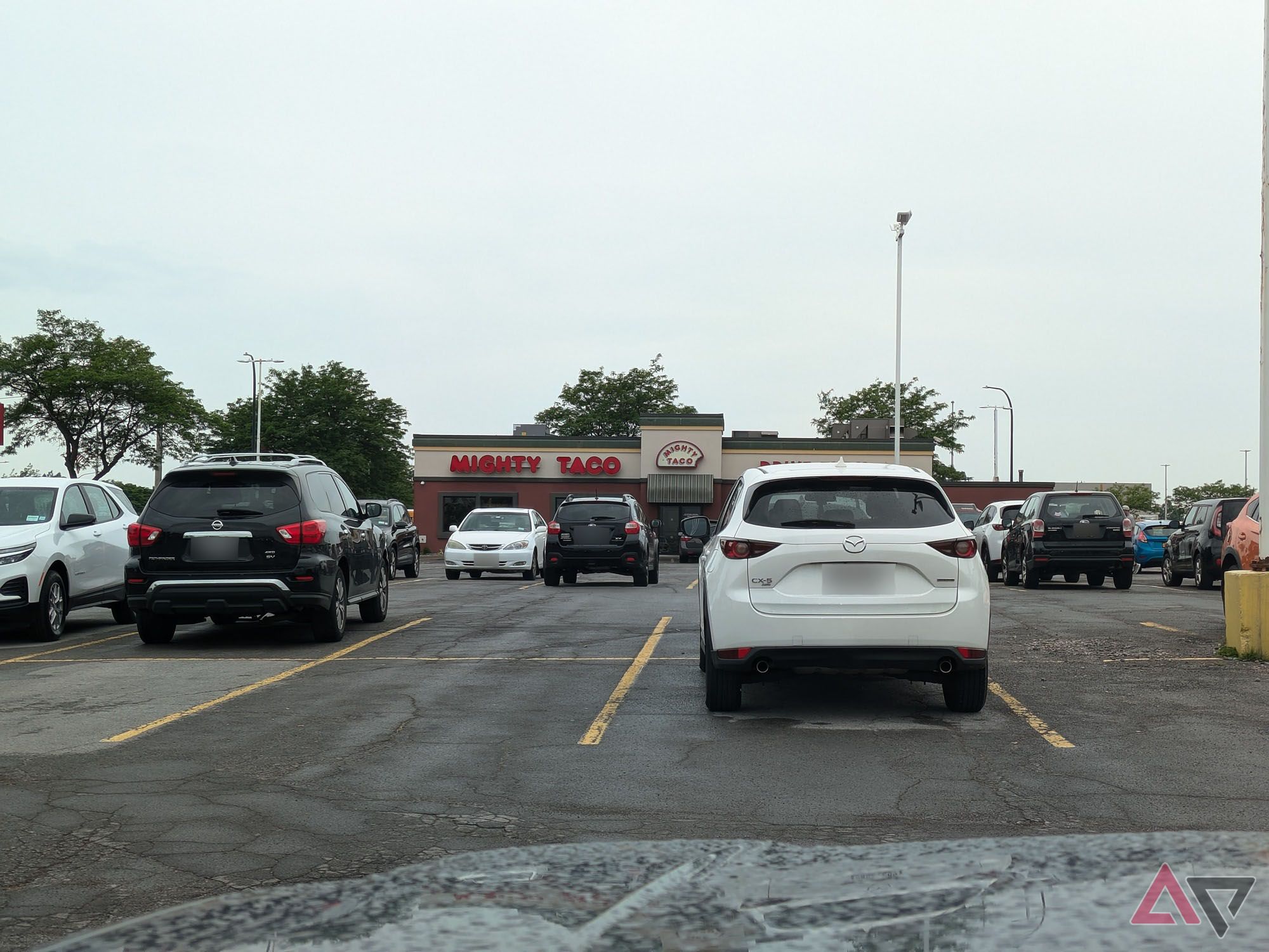 Uma foto tirada do estacionamento de um restaurante fast food ao longe.