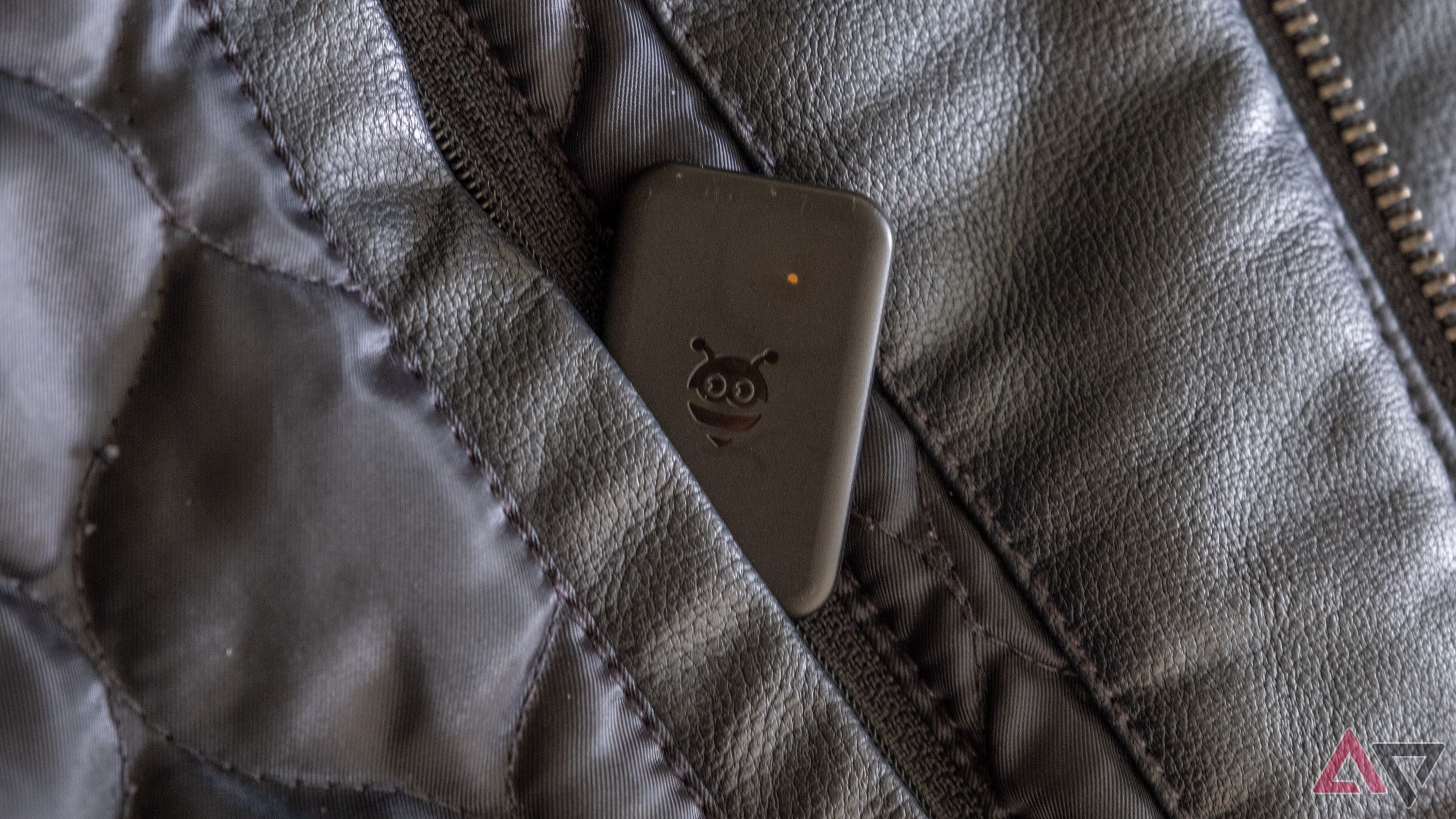 Uma etiqueta Pebblebee saindo do bolso interno da jaqueta.