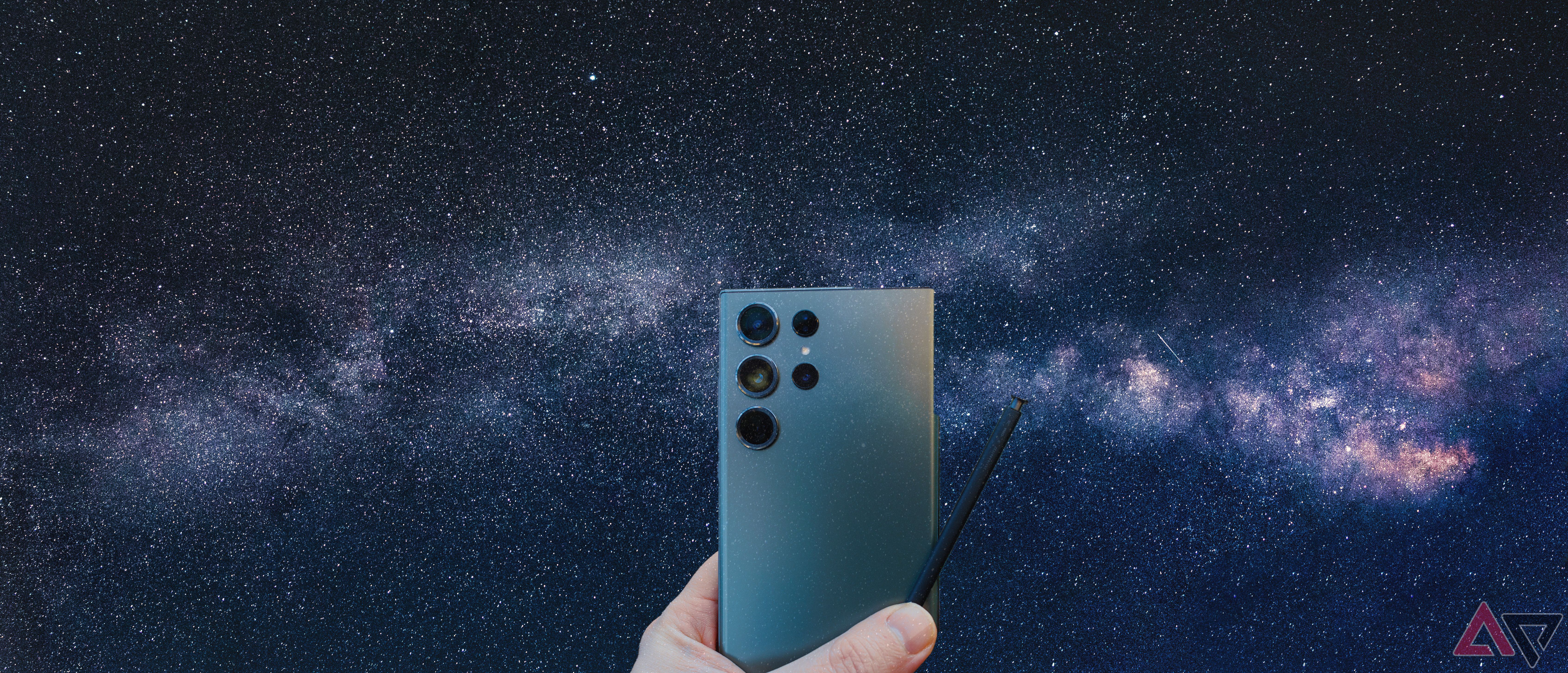 Imagem do céu noturno com uma mão segurando um Samsung S23 Ultra