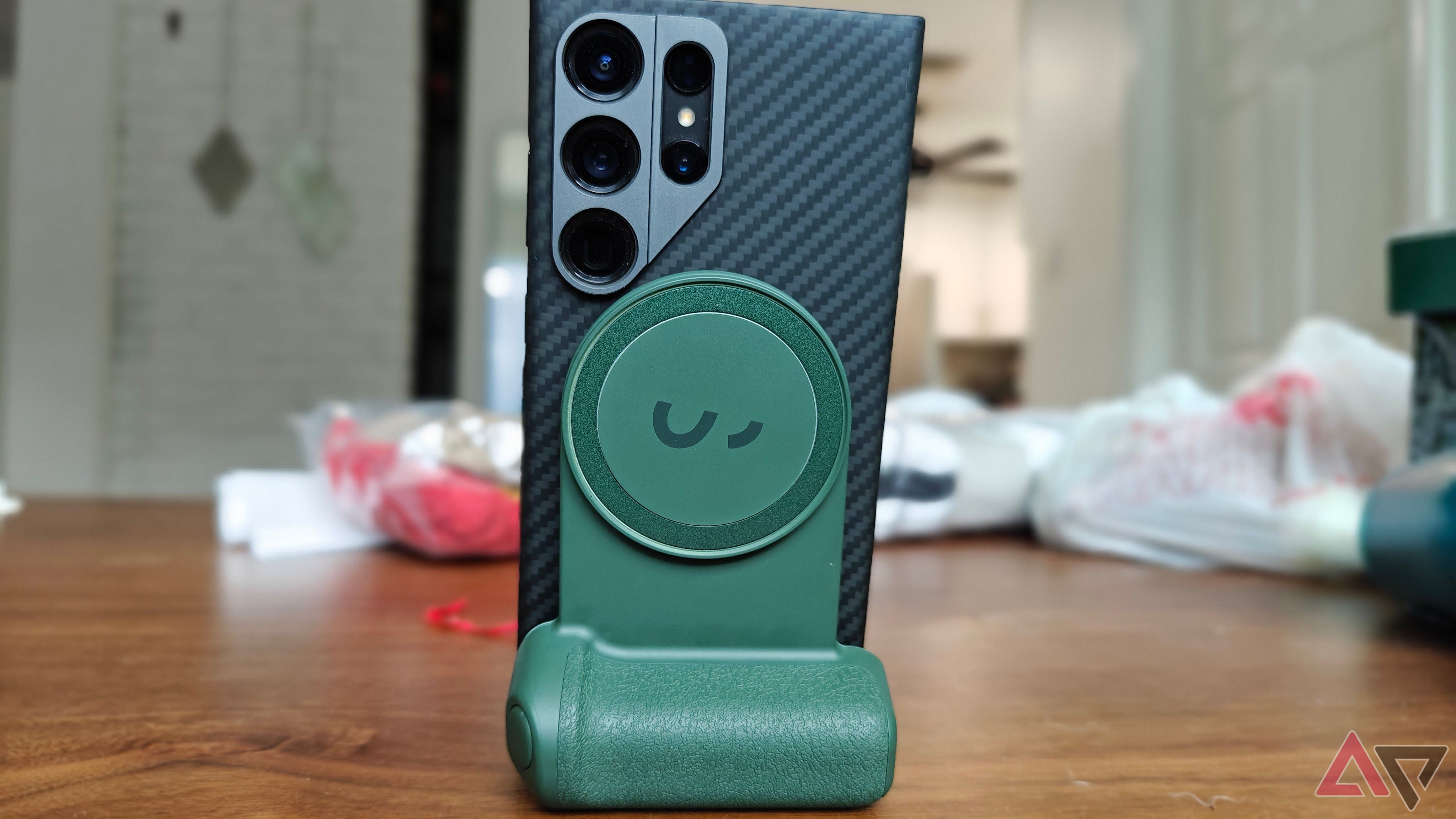Um ShiftCam SnapGrip verde segurando um smartphone preto no modo desktop