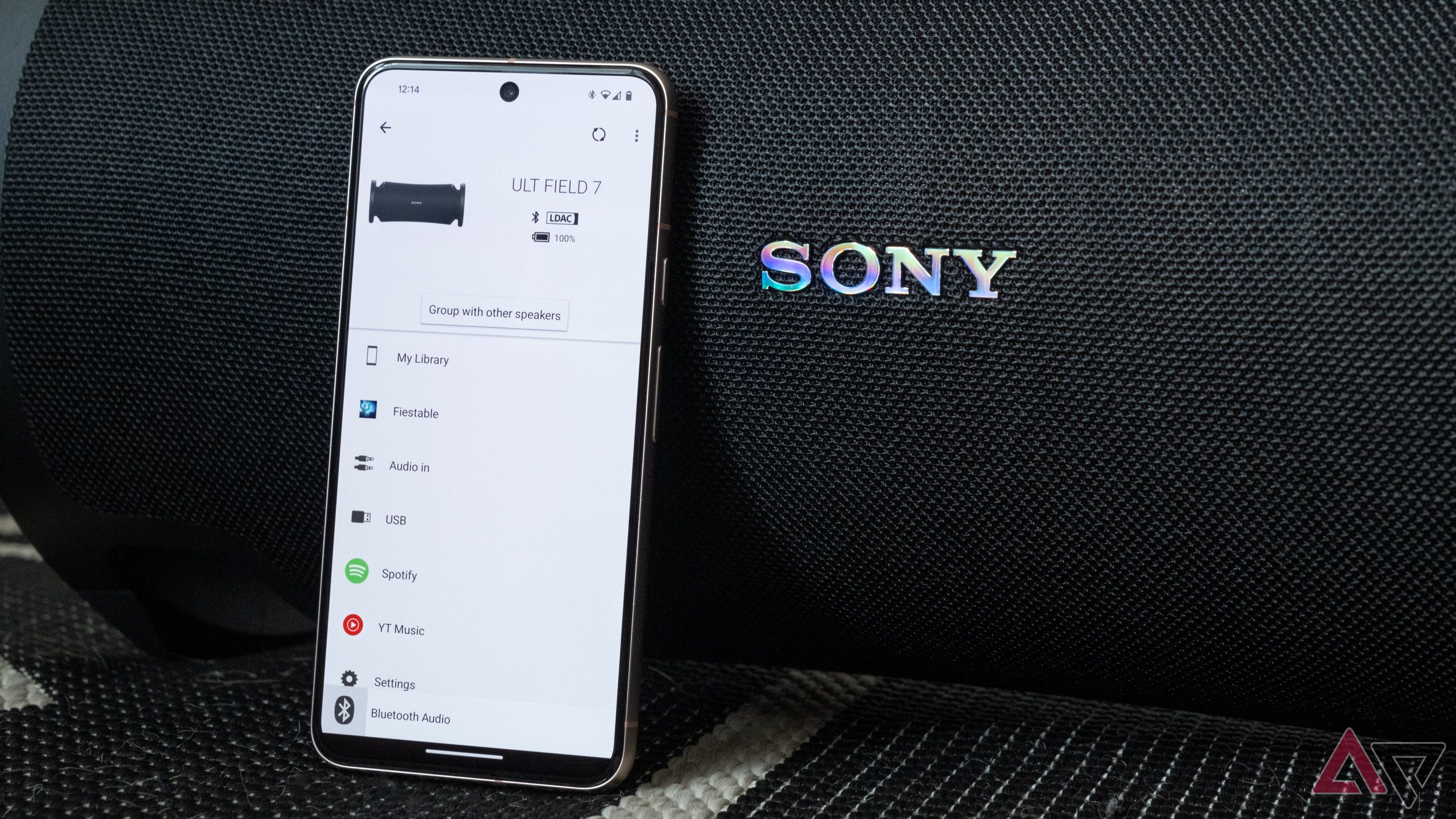 Aplicativo complementar da Sony em um telefone encostado em um alto-falante Sony