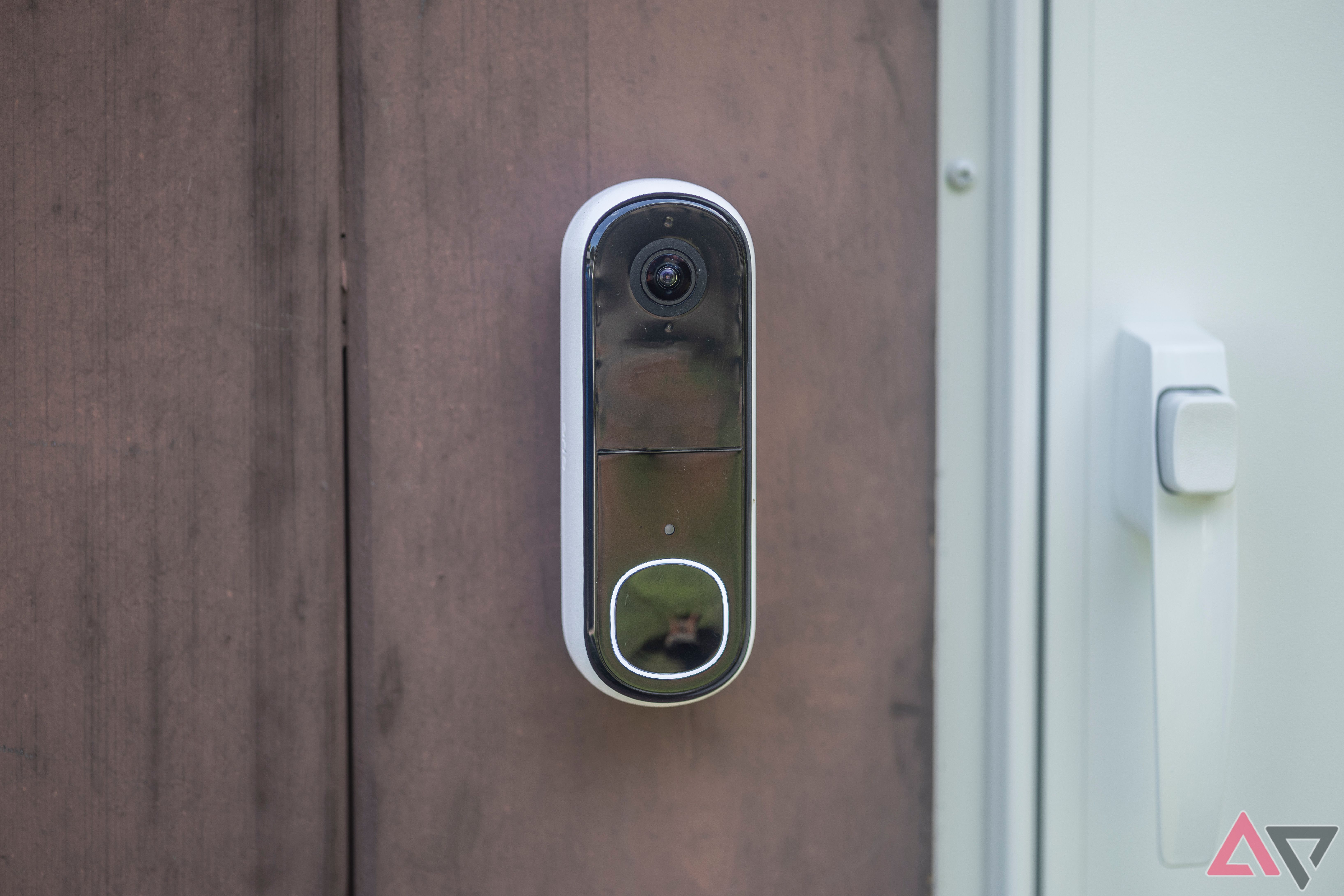 Arlo Video Doorbell (2ª geração, 2K) montada na casa por uma porta branca