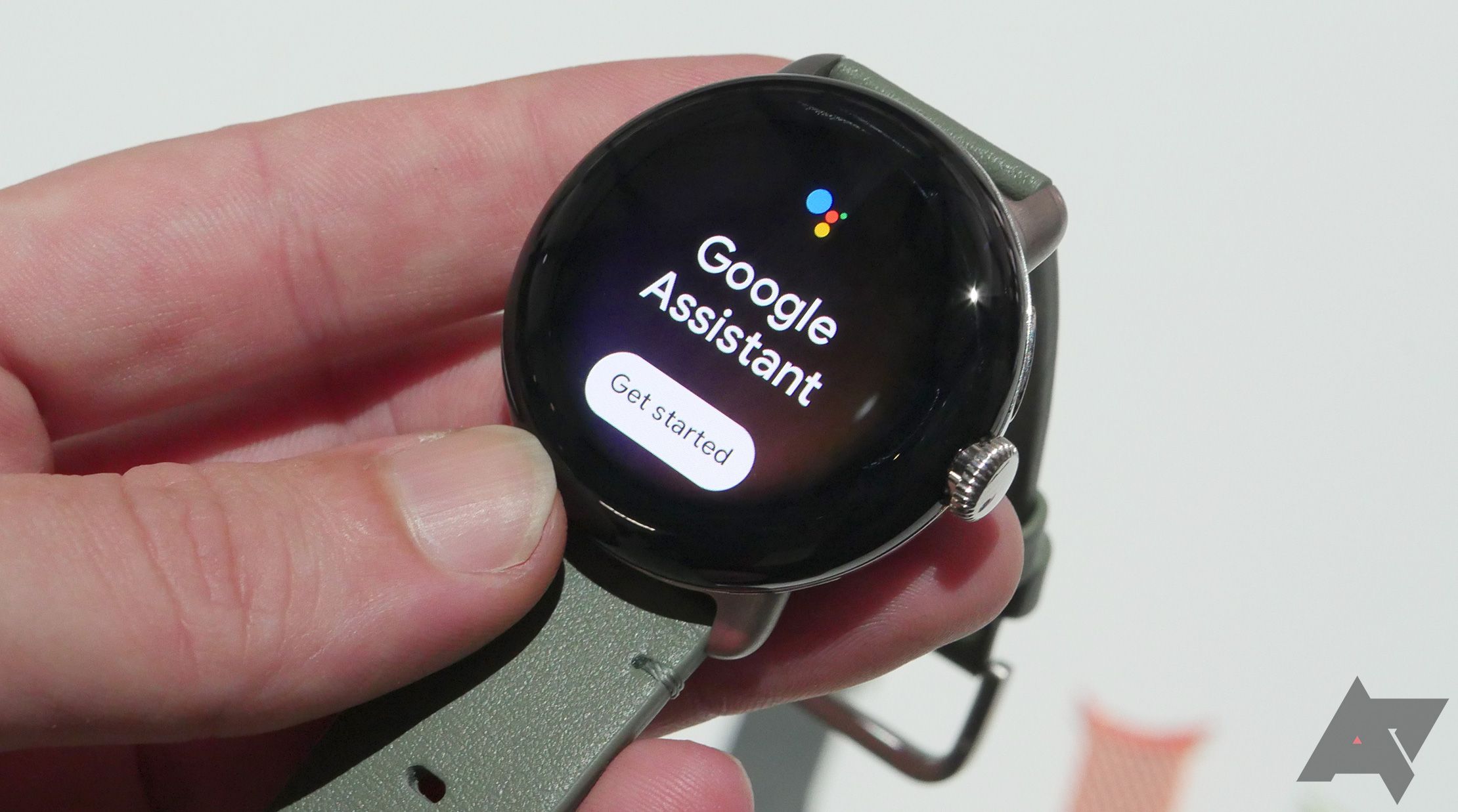 Uma mão segurando um relógio Google Pixel mostrando o Google Assistente