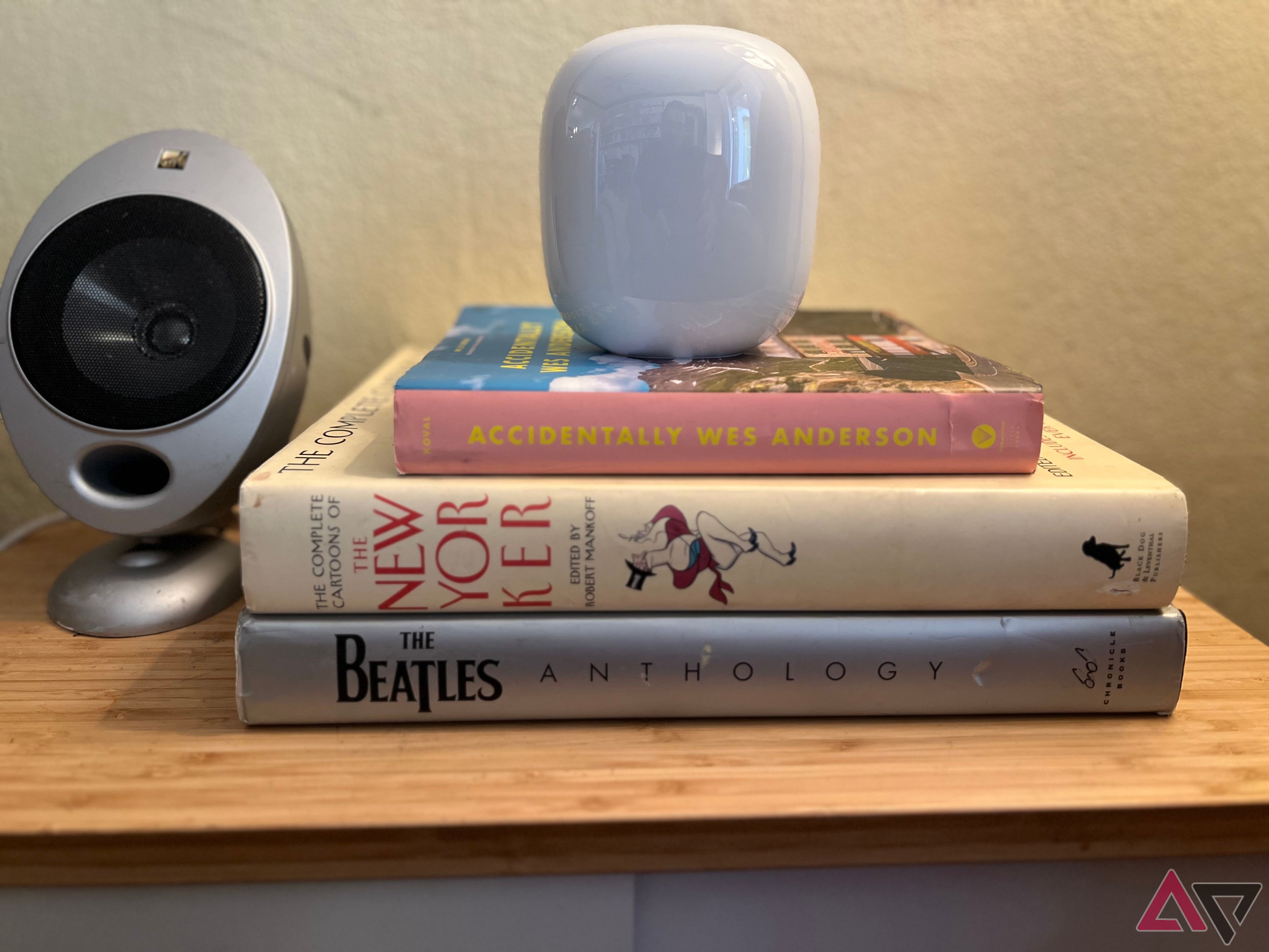 Google Nest Wifi Pro em uma pilha de livros em uma mesa lateral