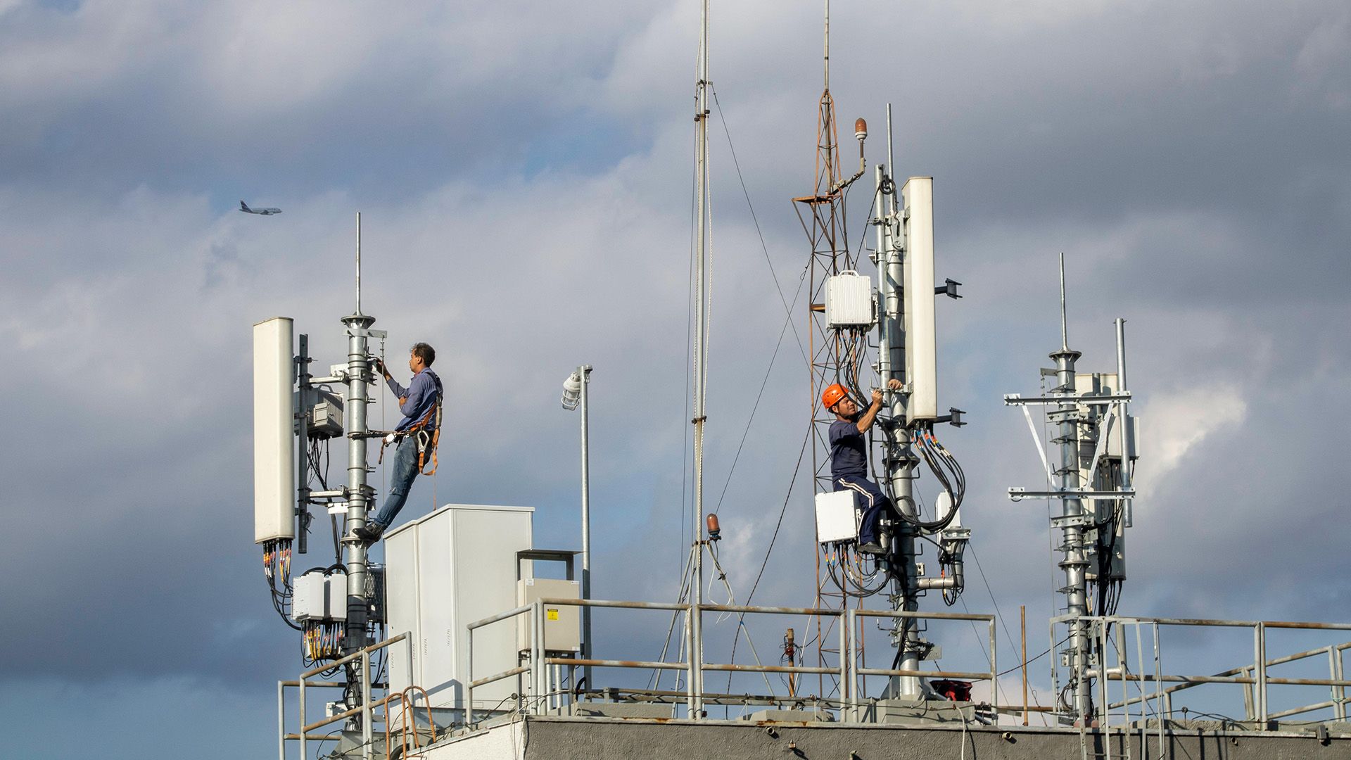 Duas pessoas trabalhando em uma torre de celular