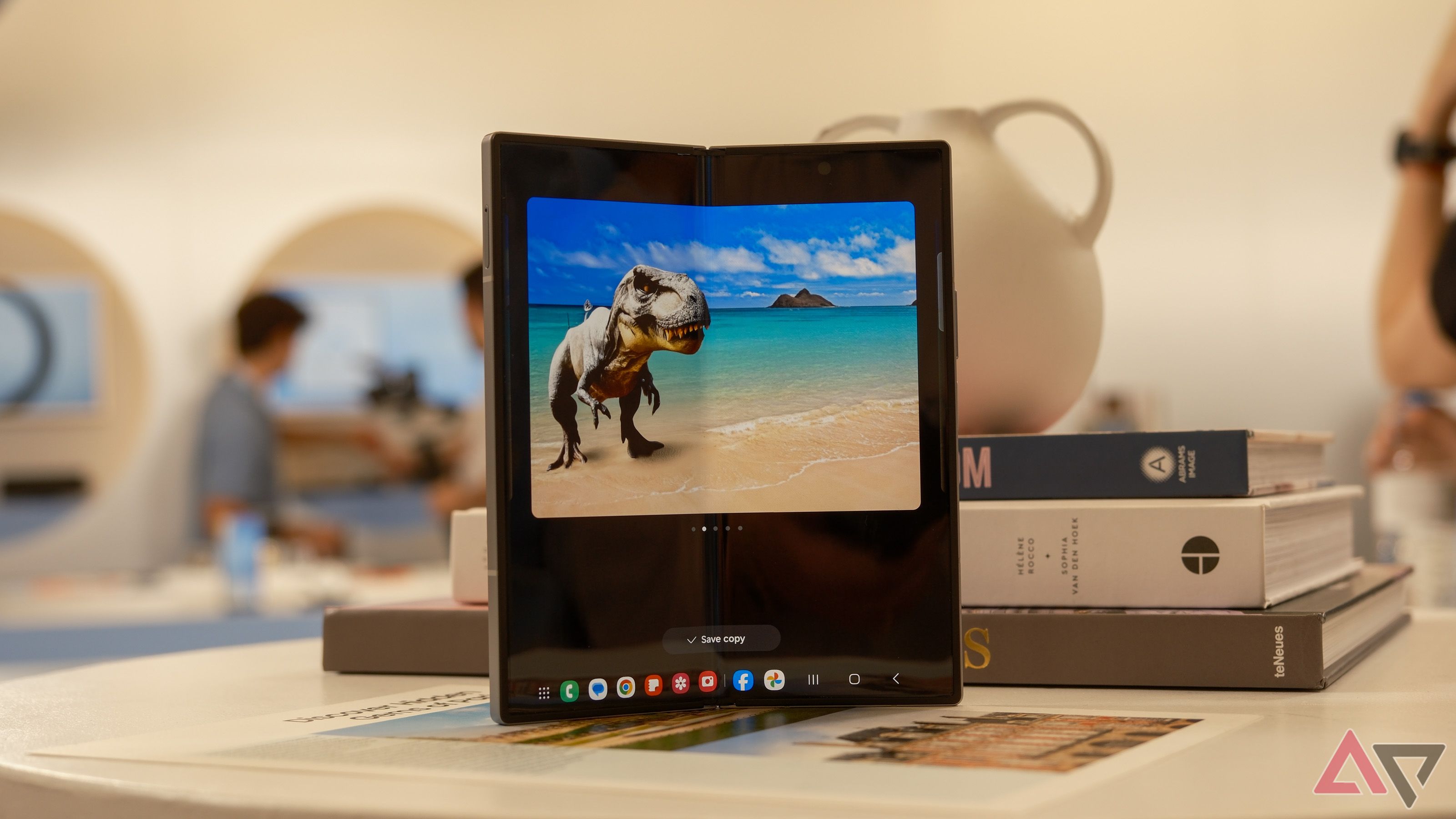 Um Samsung Galaxy Z Fold 6 em cima de uma mesa com uma imagem de IA na tela desdobrada