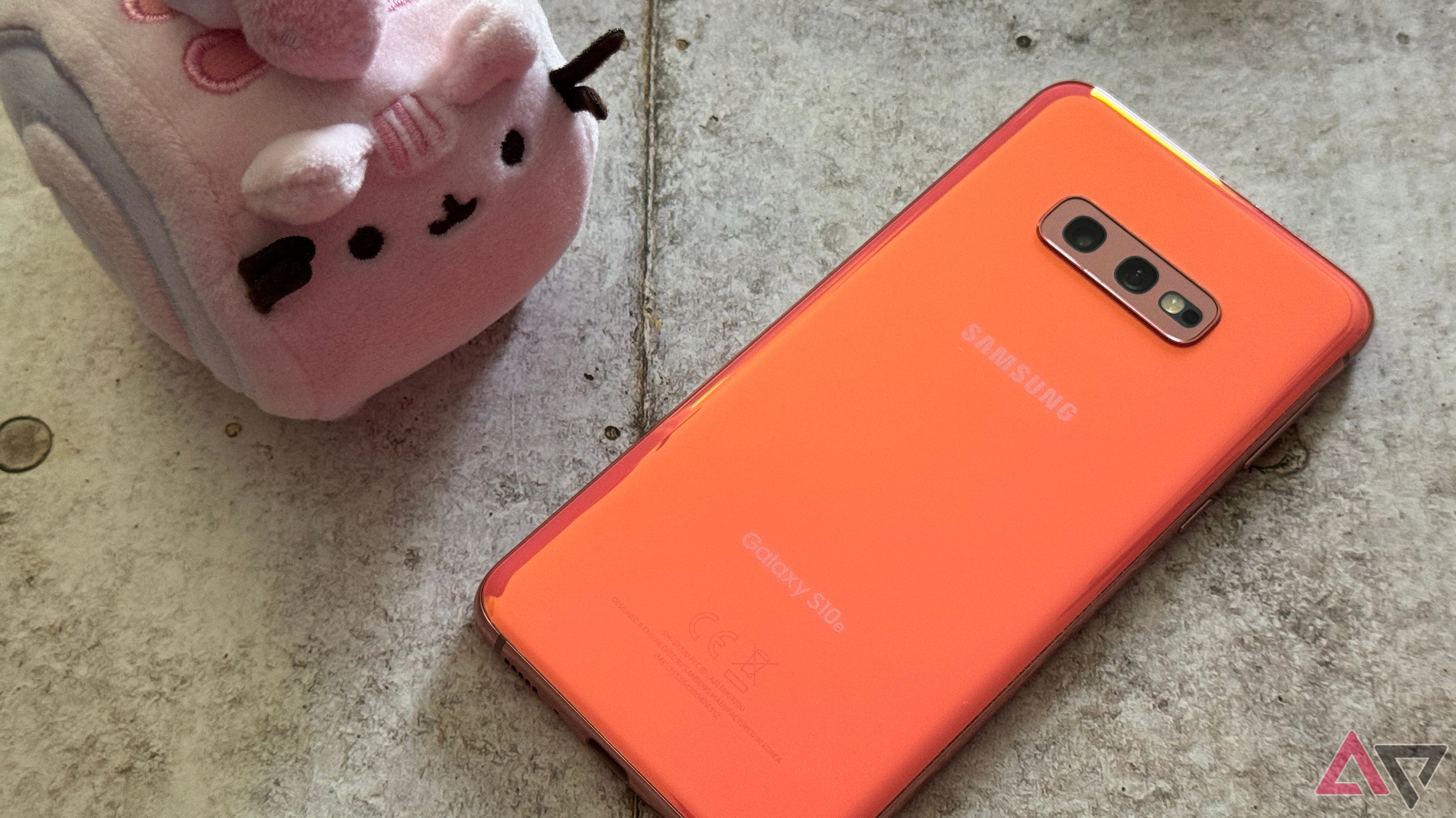 Samsung Galaxy S10e em Flamingo Pink sentado ao lado de um Pusheen