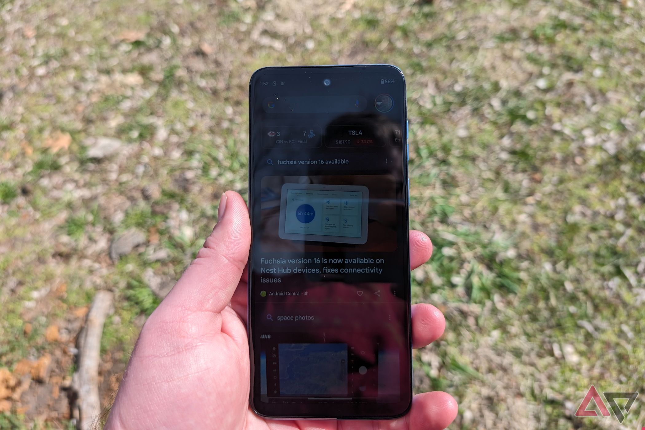 Uma pessoa segura um Moto G Play sob luz solar direta para mostrar uma tela desbotada.