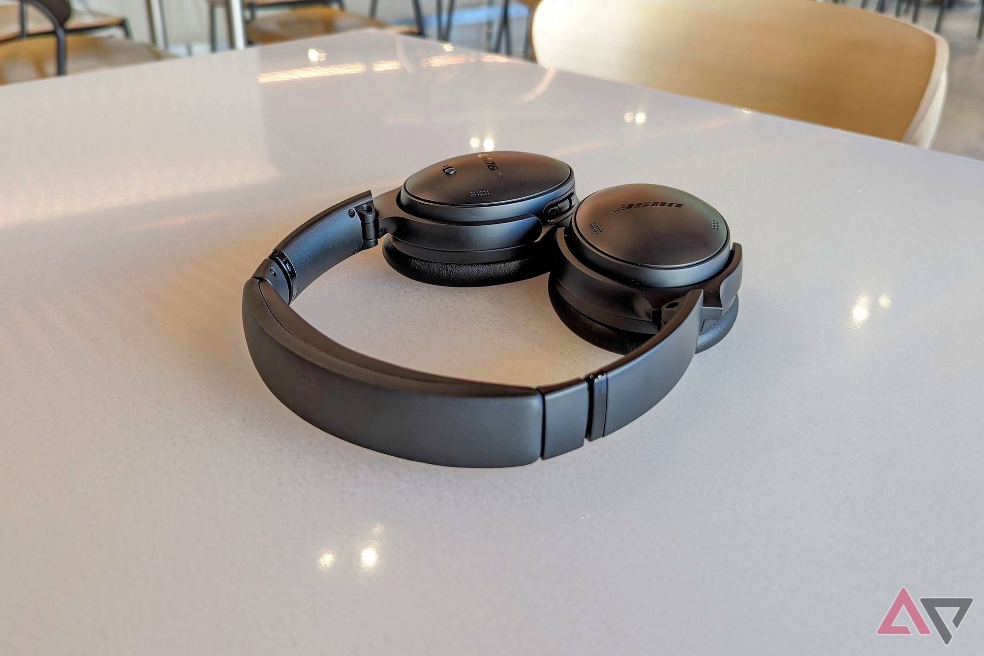 Um par preto de fones de ouvido Bose QuietComfort sobre uma mesa branca no Connections Cafe