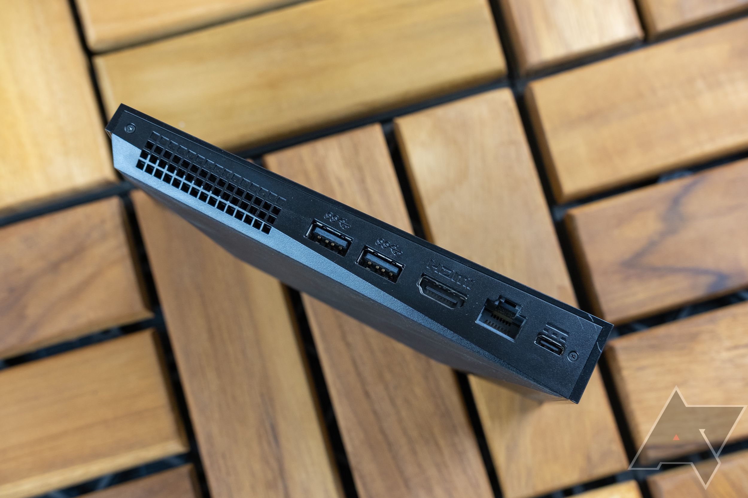 Uma imagem do dispositivo de streaming NVIDIA Shield mostrando todas as suas portas disponíveis em um fundo de superfície de madeira.