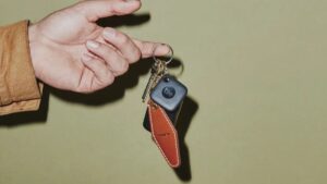 Image of a Tile Mate attached to a keyring on a green background