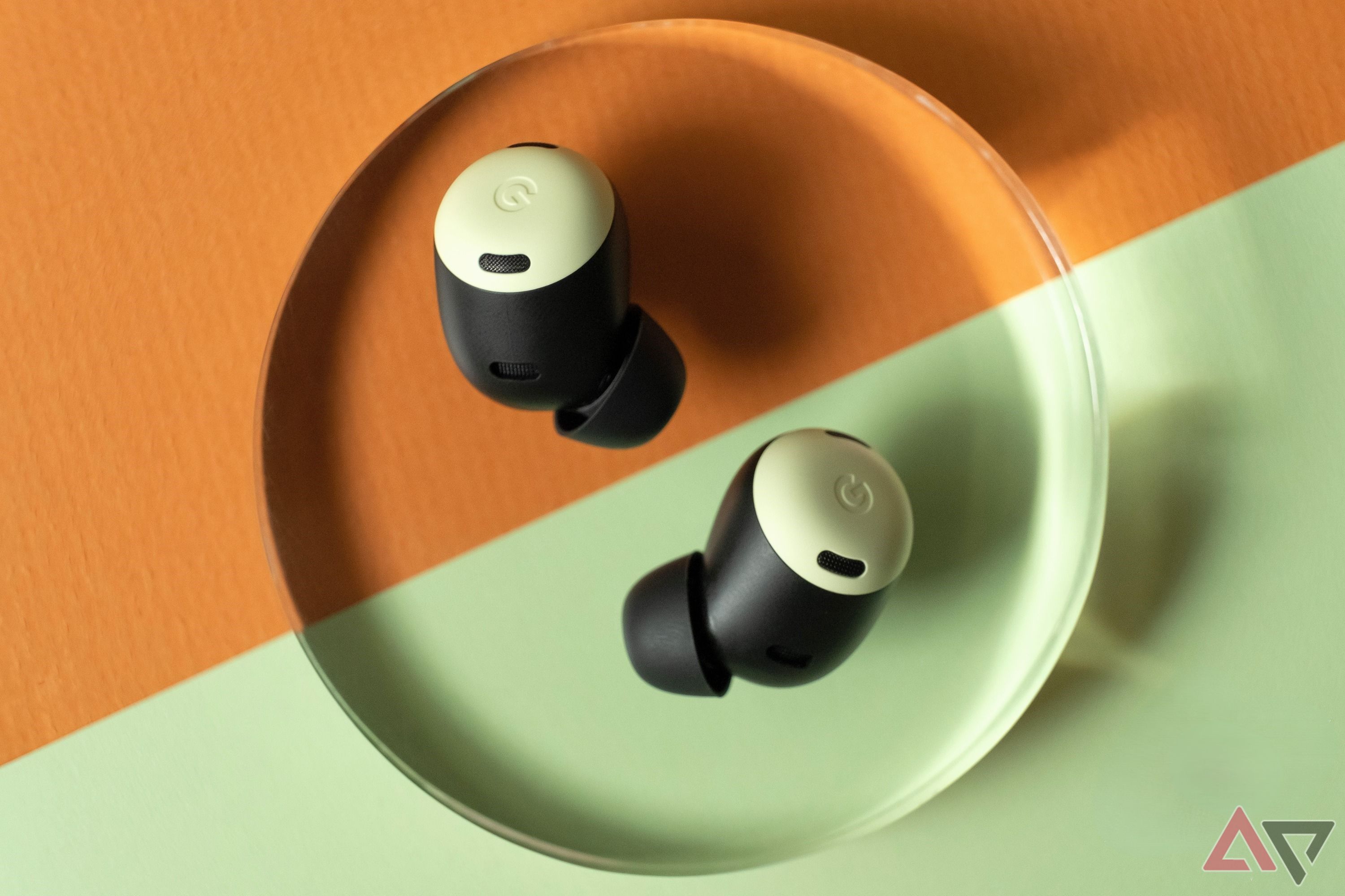 Fones de ouvido Google Pixel Buds em um fundo laranja e verde