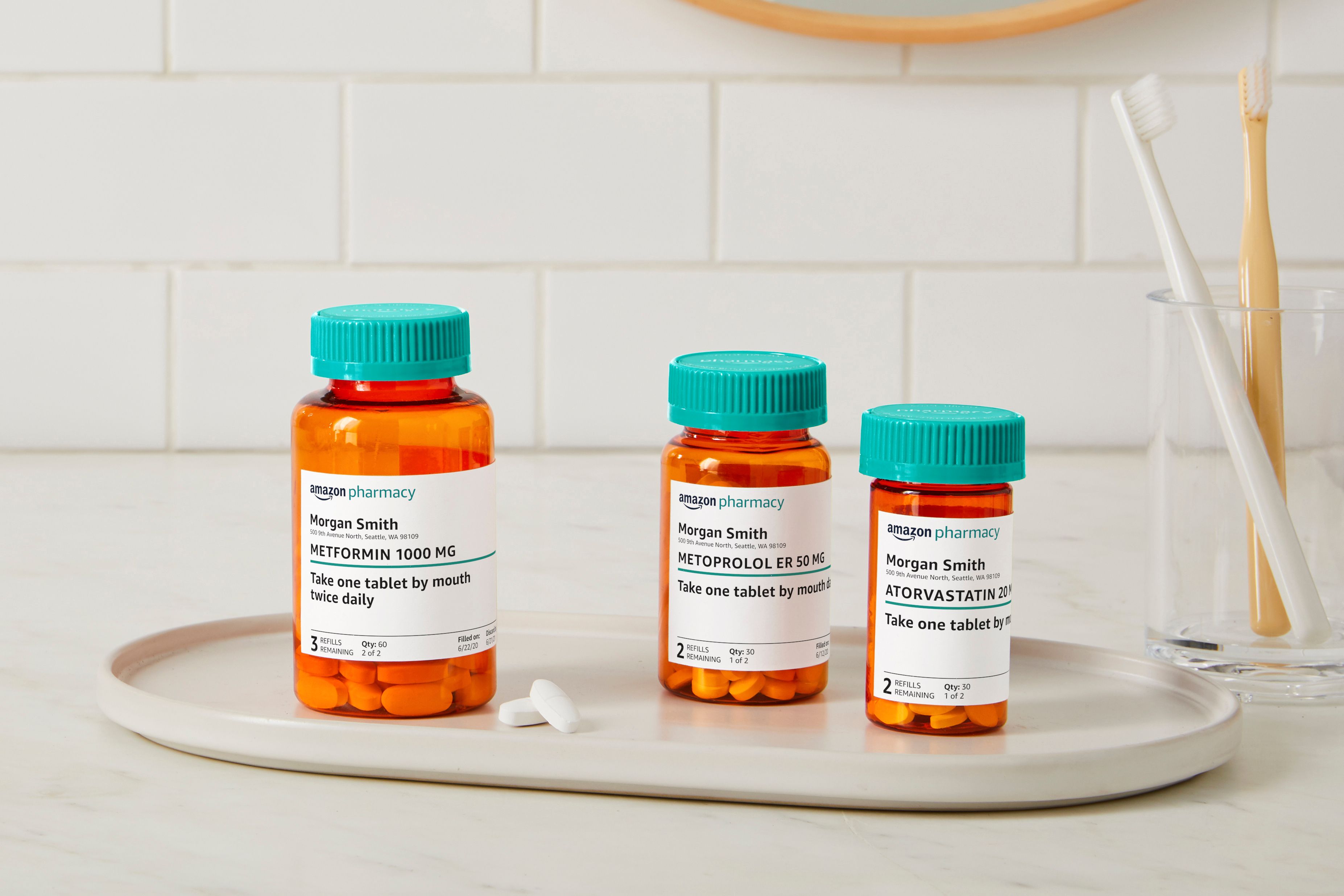 Três frascos de remédios em uma bandeja com rótulos da Amazon Pharmacy em cada frasco.