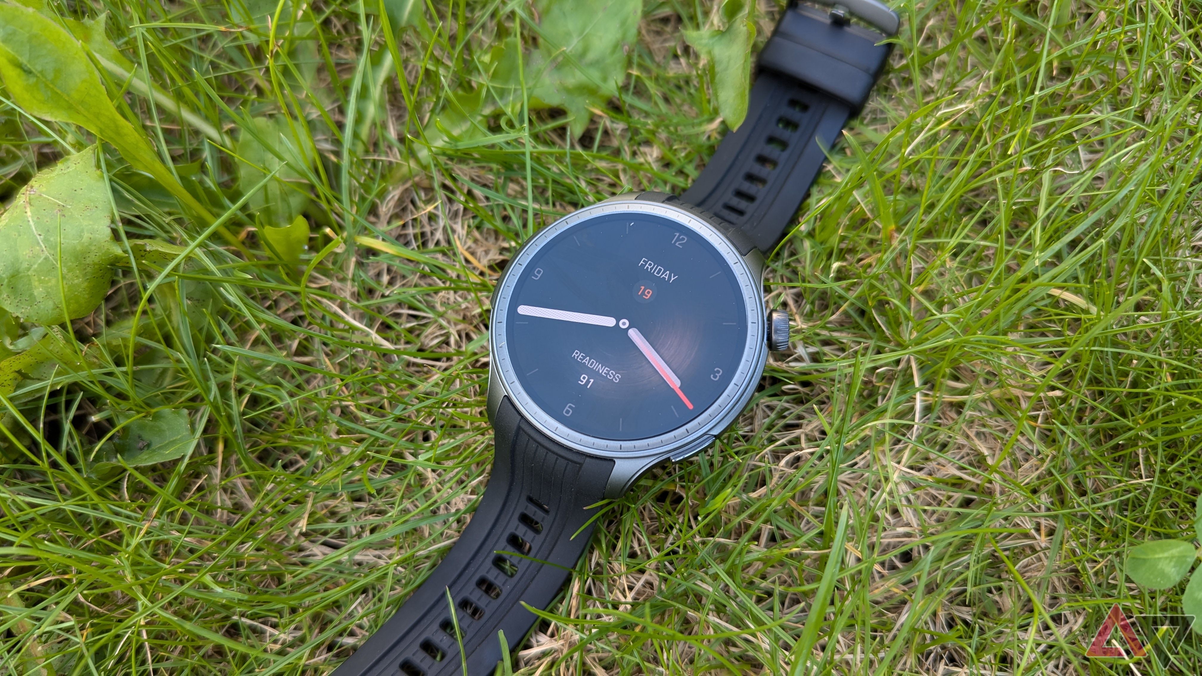 Relógio inteligente Amazfit Balance na cor Midnight ao ar livre deitado na grama