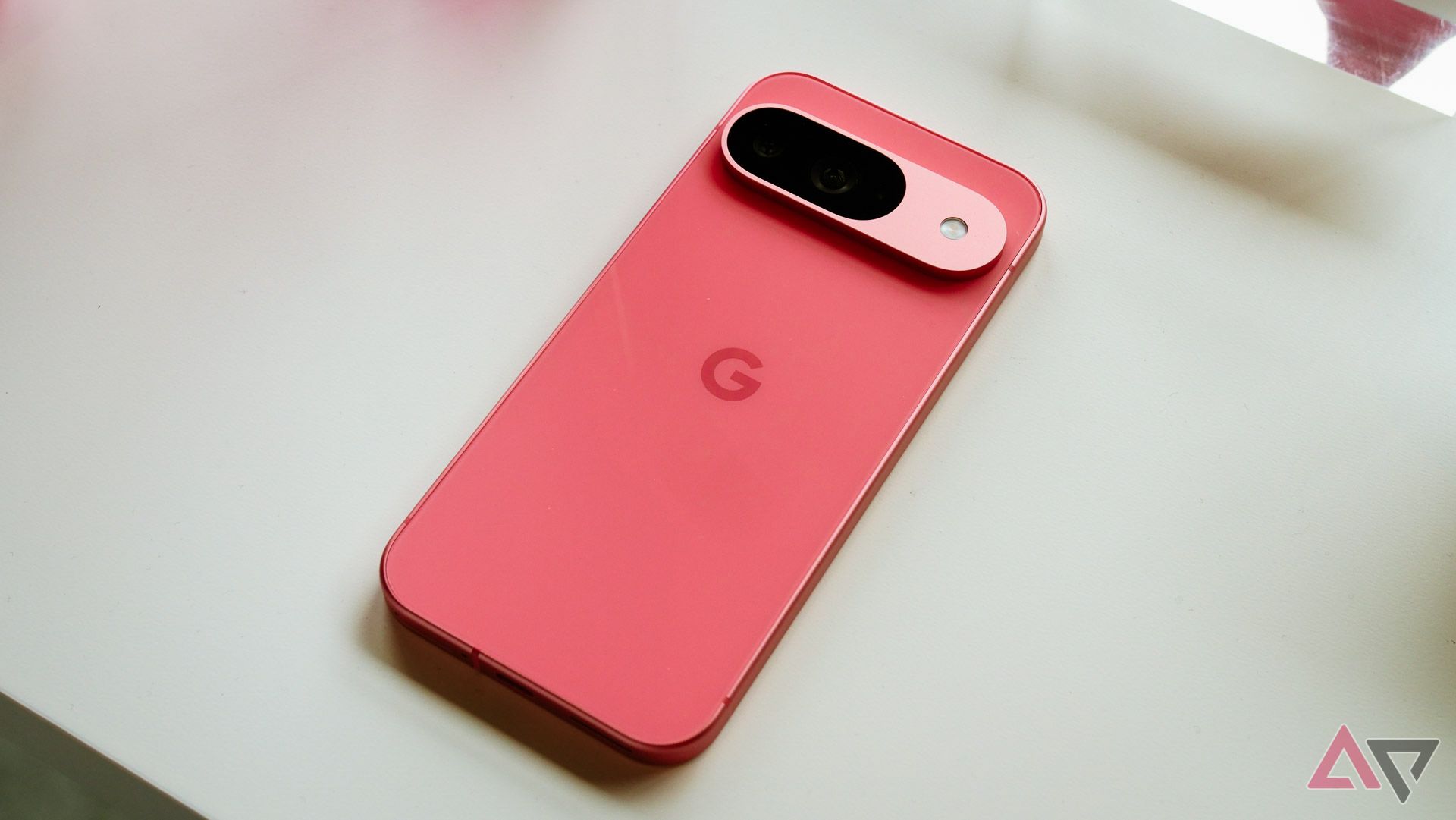 Google Pixel 9 rosa virado para baixo sobre uma mesa