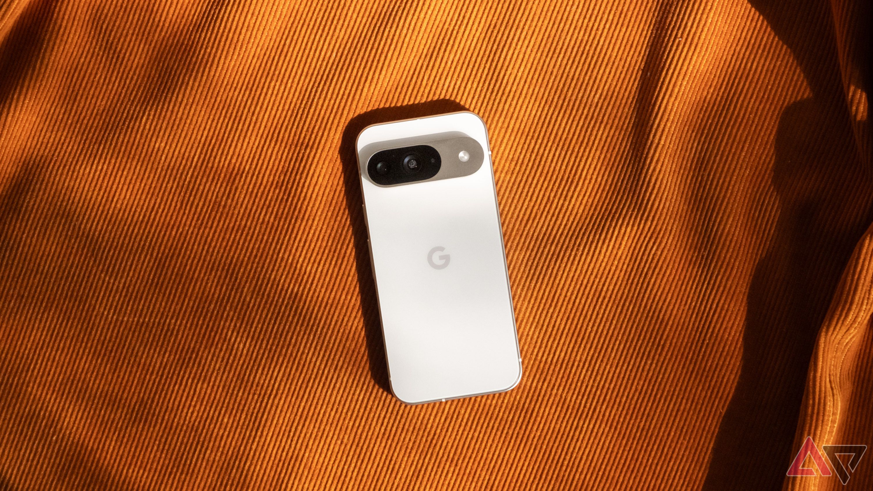 Google Pixel 9 em um tecido laranja mostrando a parte traseira do telefone