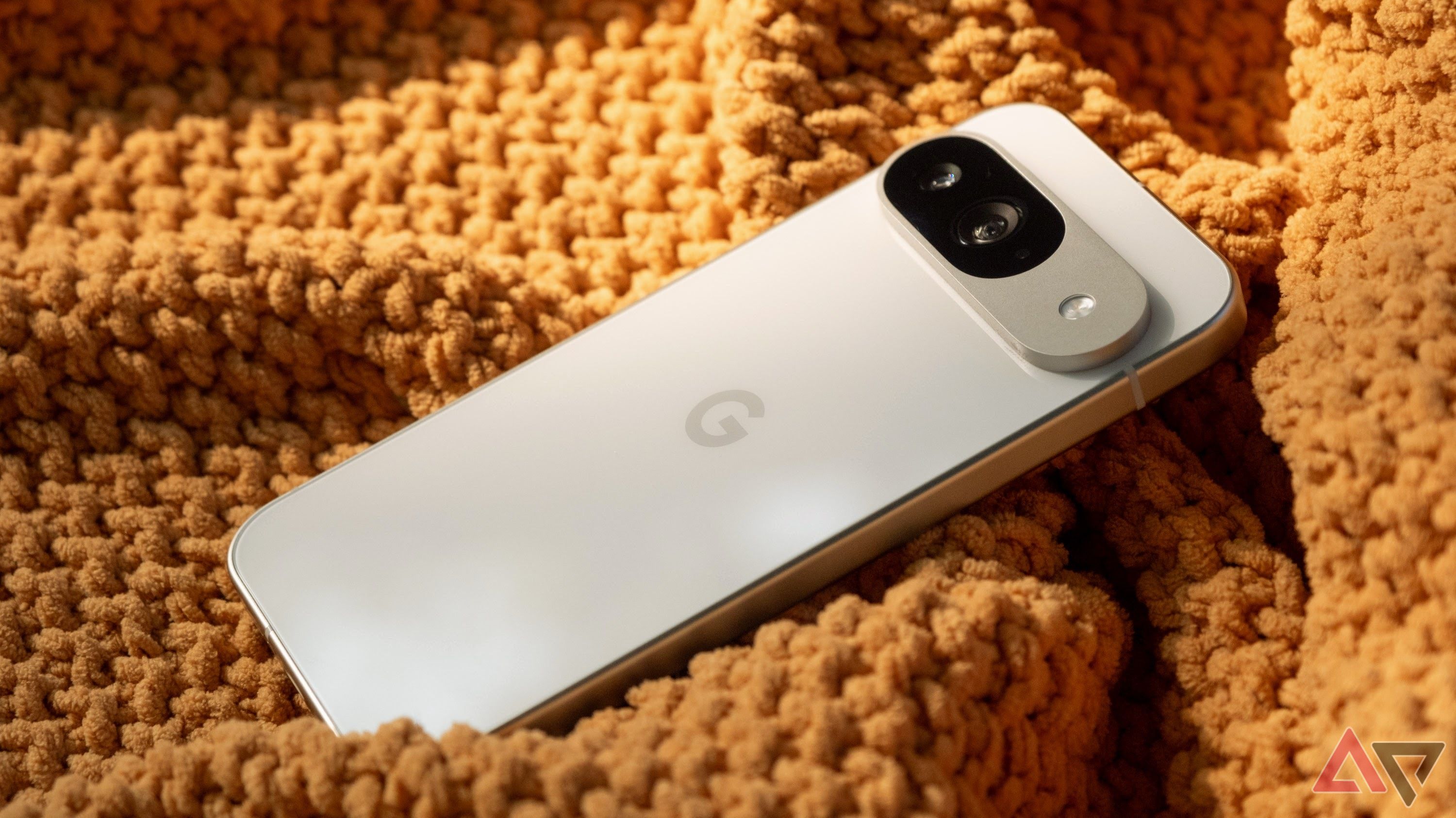 Google Pixel 9 em um tecido laranja mostrando a parte traseira do telefone