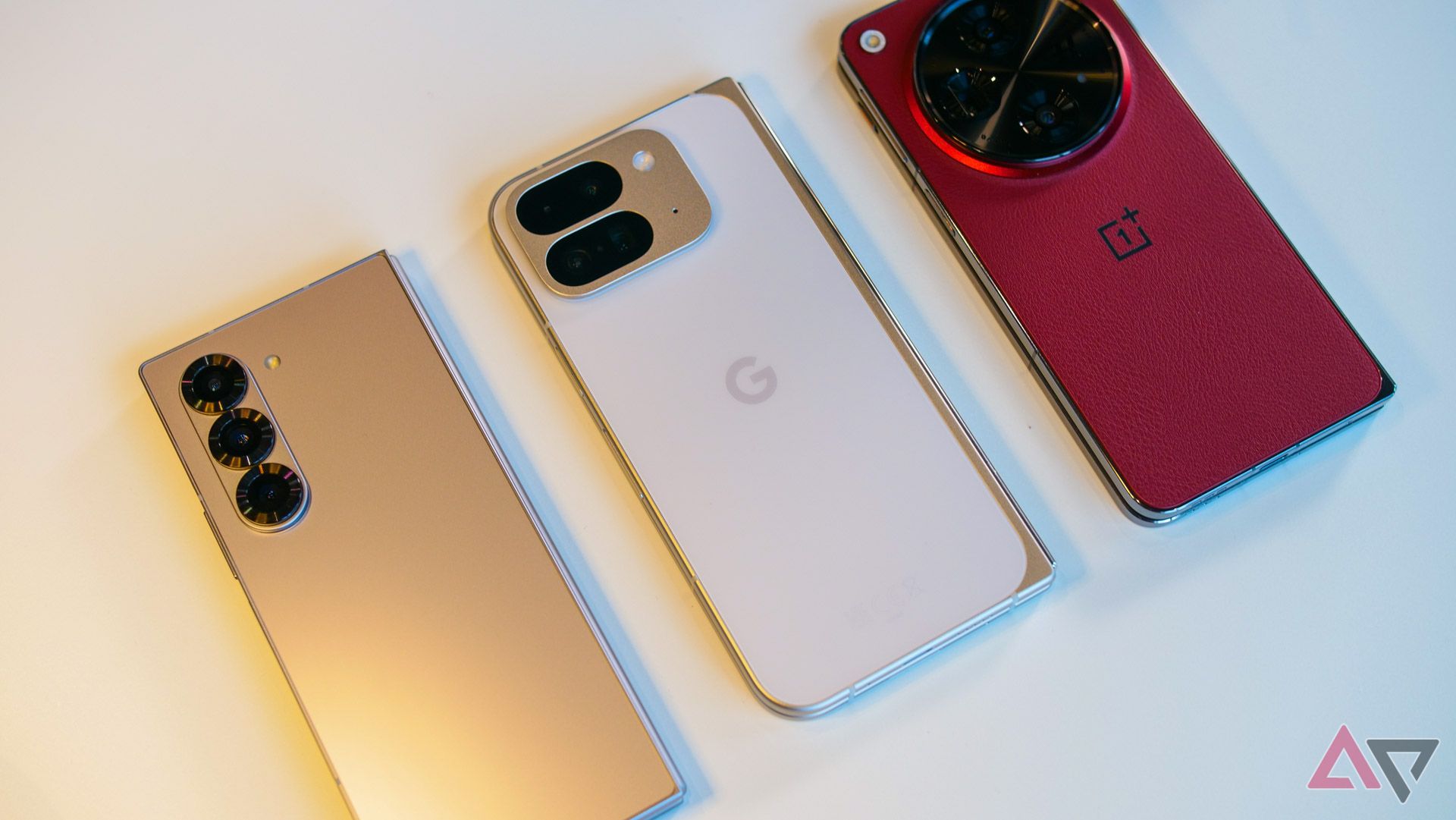 O Pixel 9 Pro Fold branco ao lado do Galaxy Z Fold 6 e do OnePlus Open.