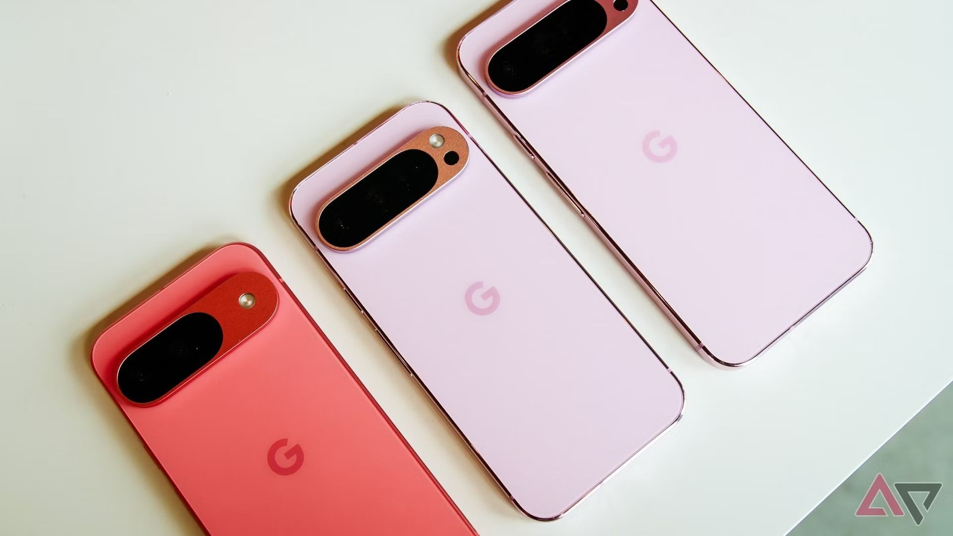 Três modelos rosa do Google Pixel 9 virados para baixo.