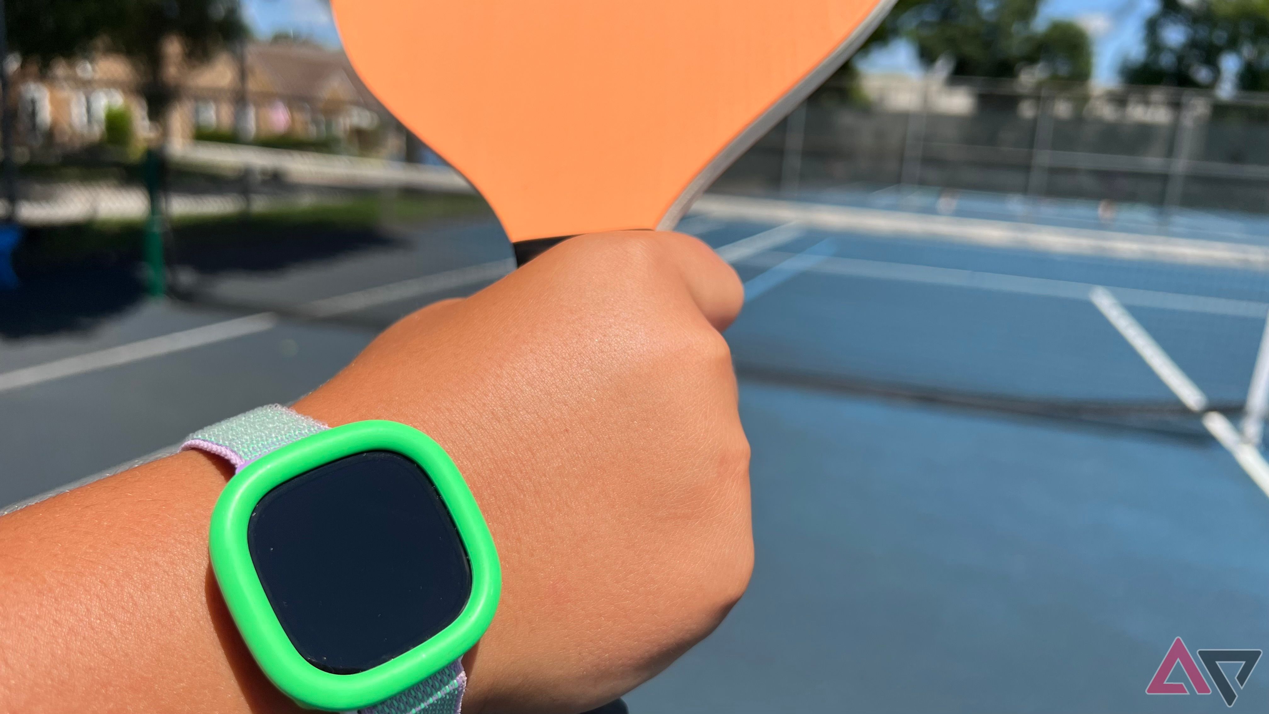 Pessoa usando Fitbit Ace LTE enquanto joga pickle ball