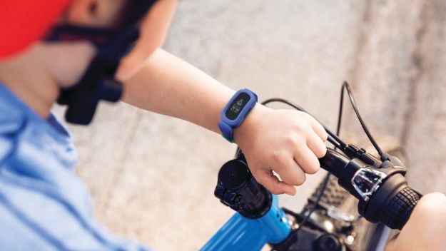 Criança olhando para Fitbit Ace 3 em bicicleta