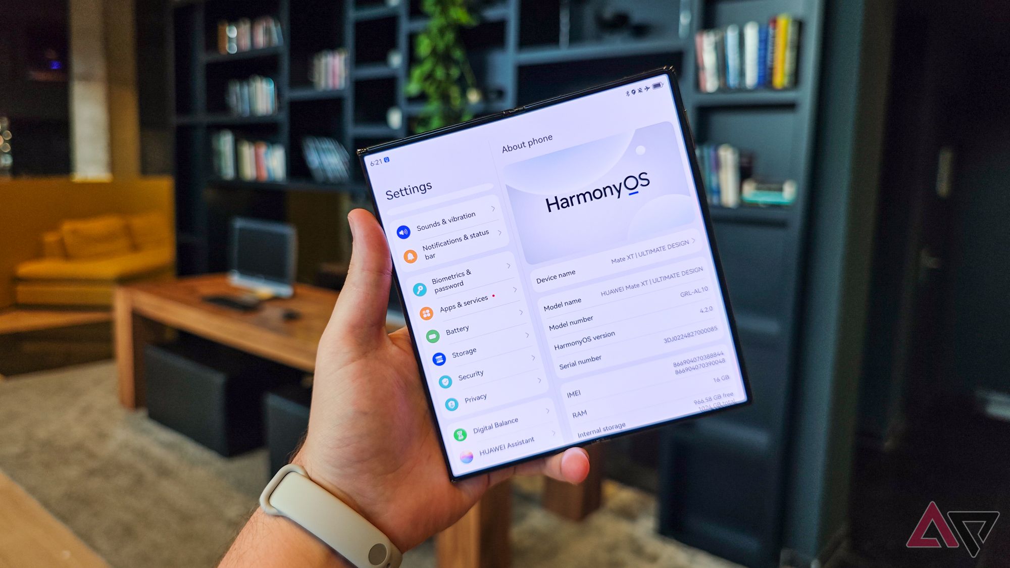 Huawei Mate XT segurado na mão de alguém com duas seções de tela abertas mostrando as configurações do HarmonyOS