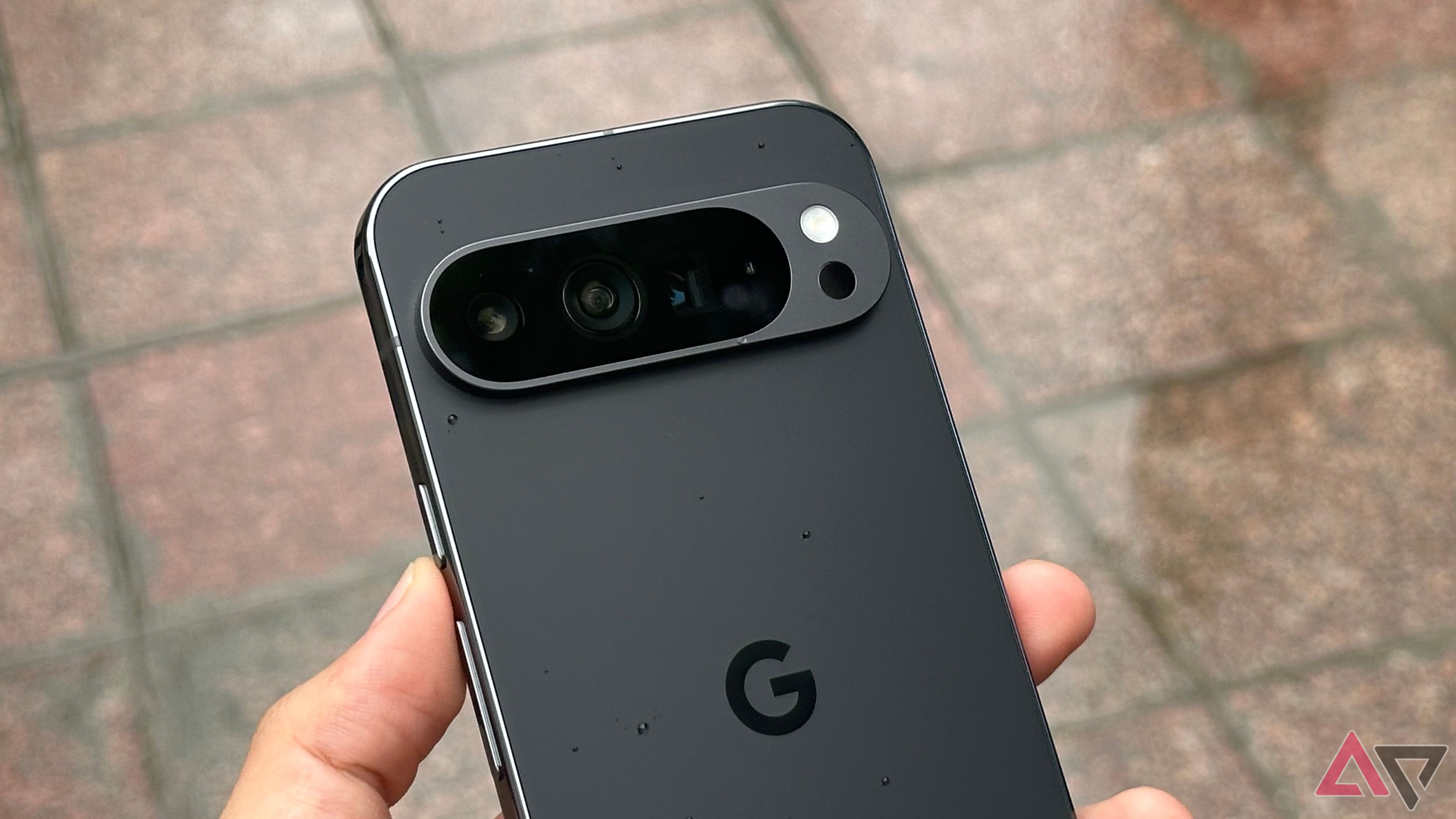 Google Pixel 9 Pro XL na mão com gotas de água no topo