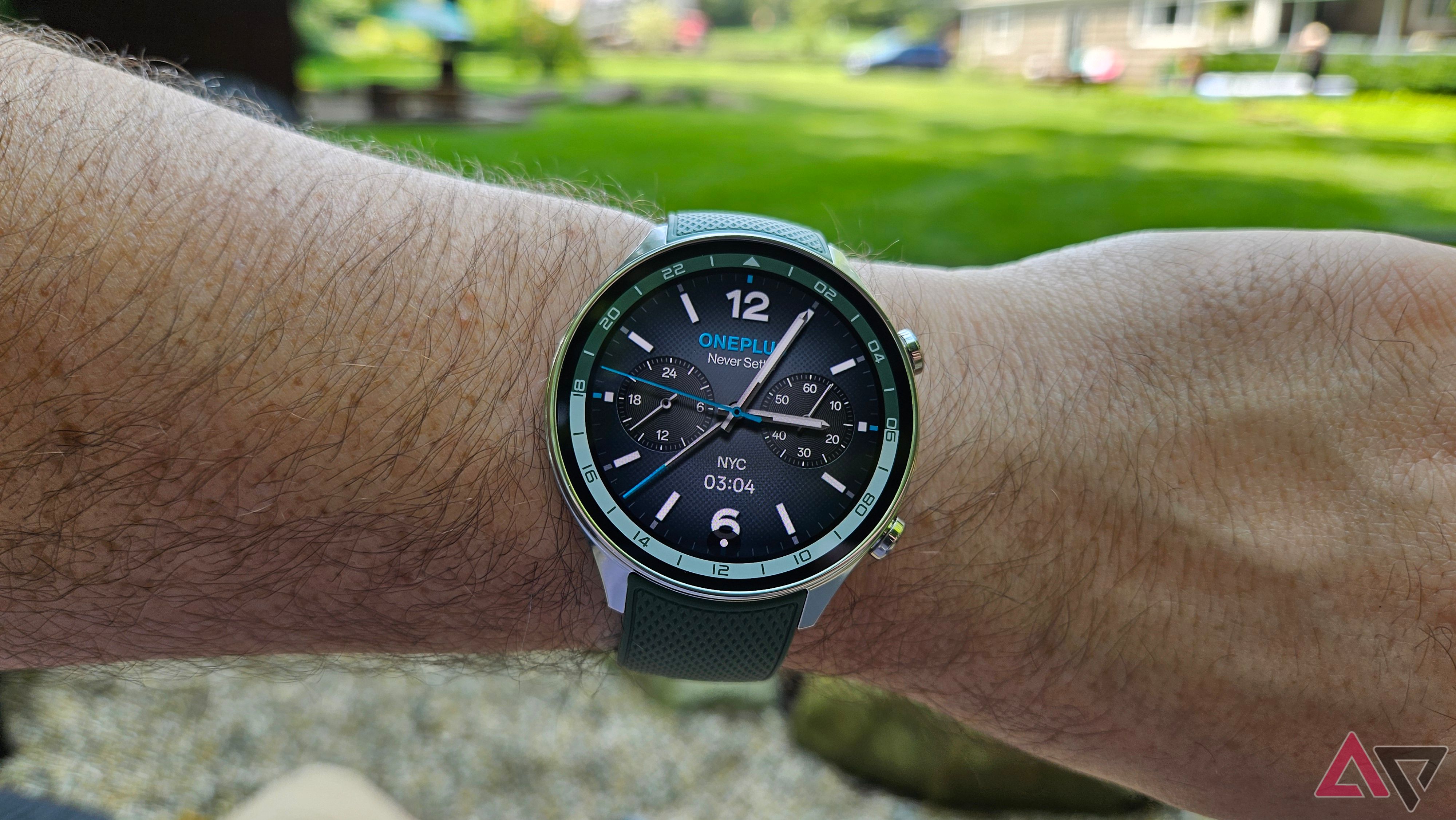 OnePlus Watch 2R usado no pulso com grama verde ao fundo