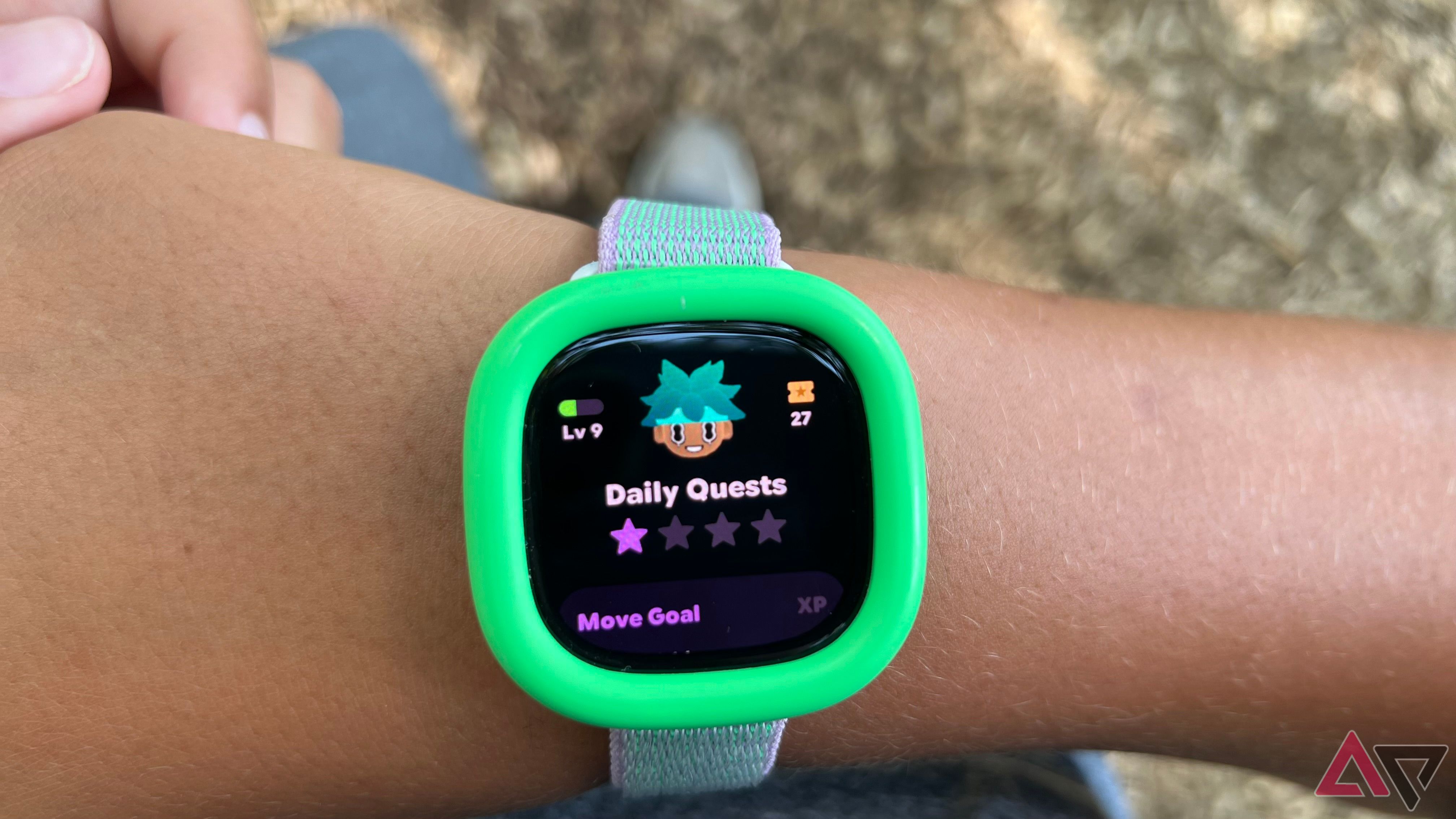 Fitbit Ace LTE no pulso com tela mostrando Daily Quests