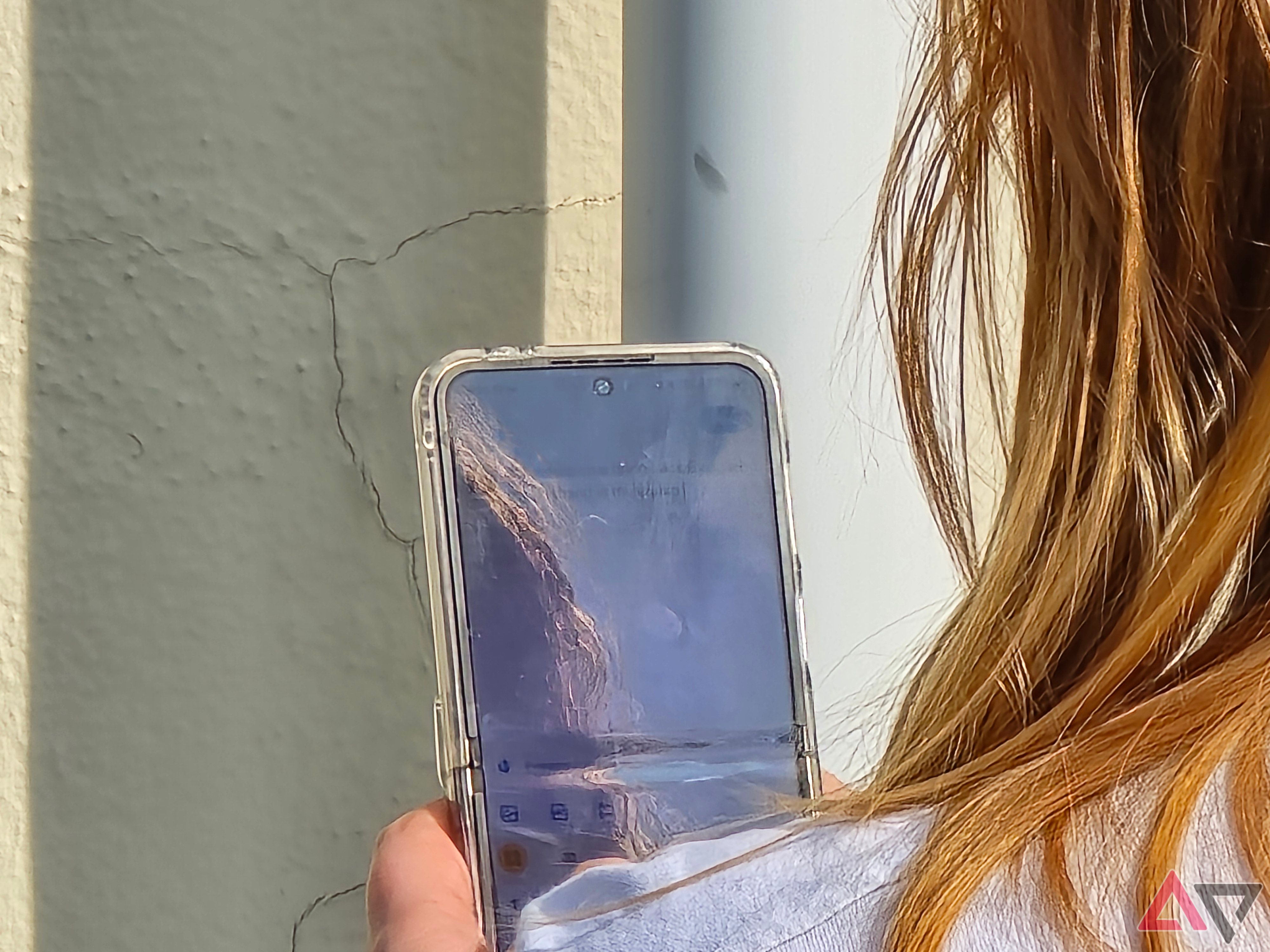 Uma foto de uma mulher segurando um Galaxy Z Flip 5, a foto está ampliada e não tem detalhes