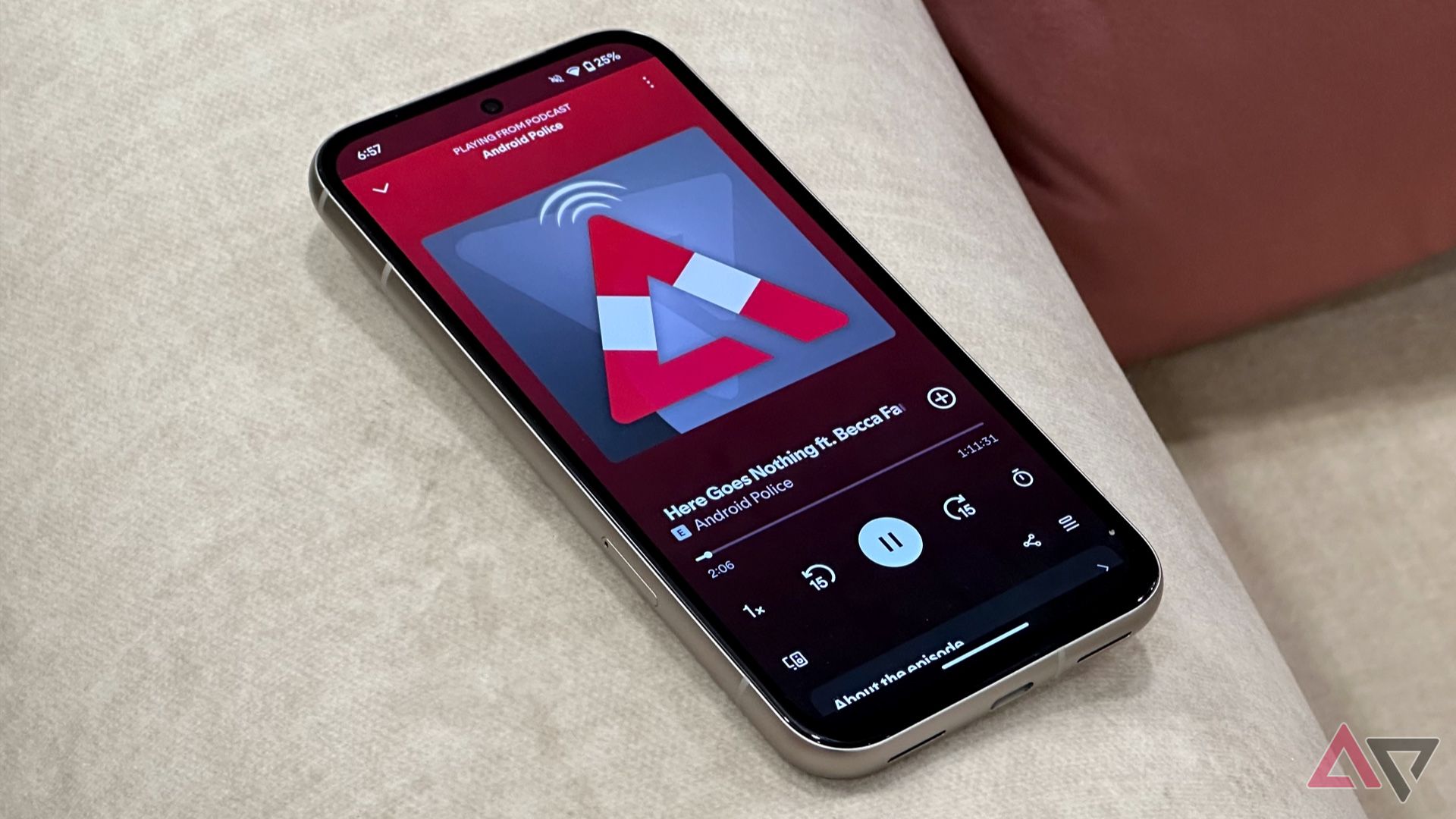 Pixel 8a em um sofá branco com podcast do Android Police sendo reproduzido no Spotify
