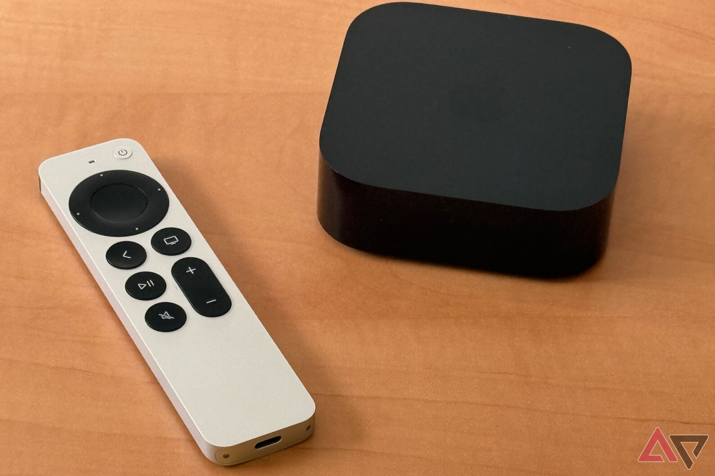 Apple TV 4K e Siri Remote sobre uma mesa de madeira marrom clara