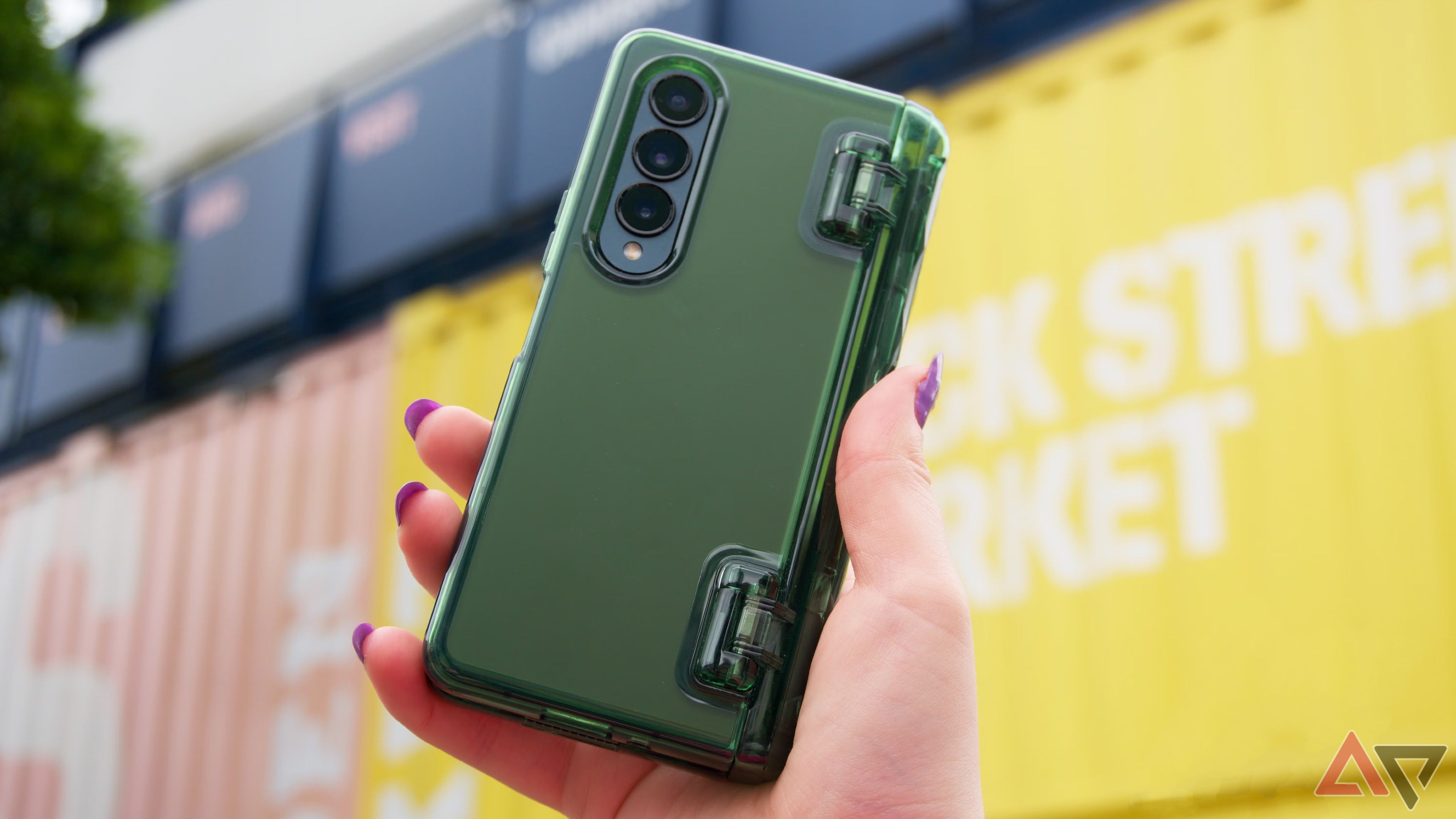 Uma foto de um Galaxy Z Fold 4 em uma caixa verde levantada atrás 