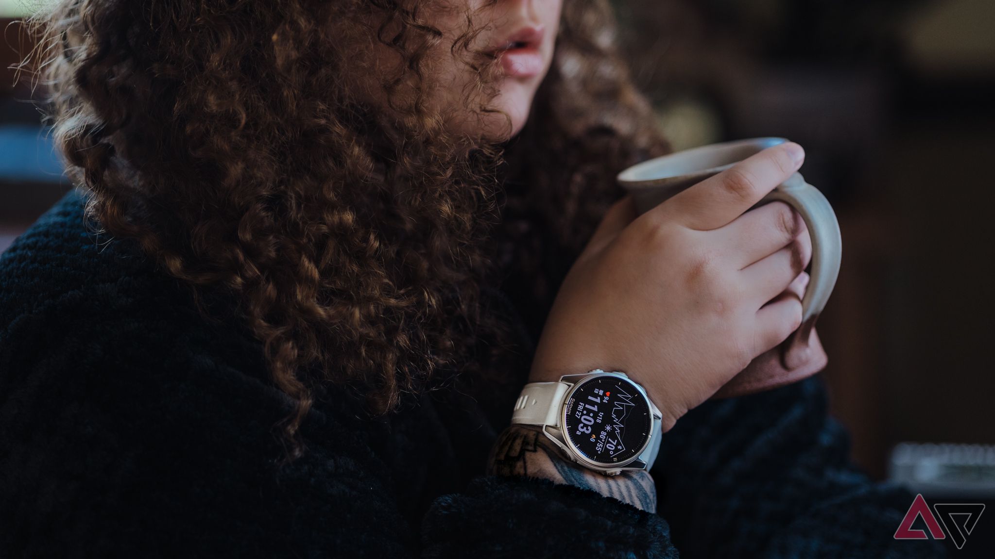 Mulher usando smartwatch Garmin Fenix ​​8 segurando uma caneca de café