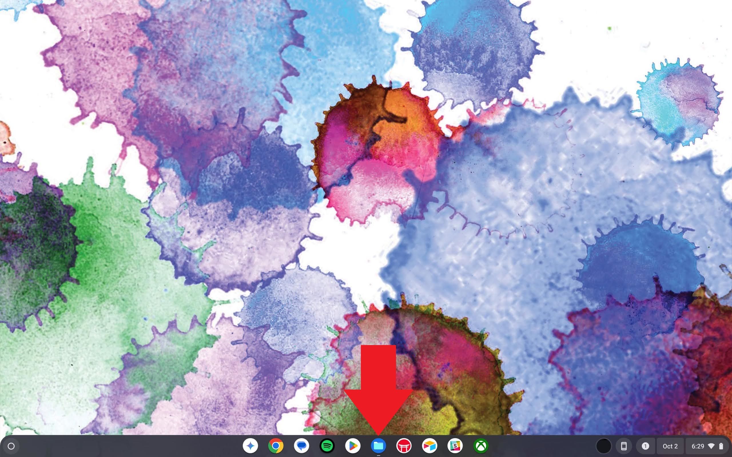 Uma tela inicial do Chromebook com uma seta vermelha apontando para o ícone do aplicativo Arquivos na estante